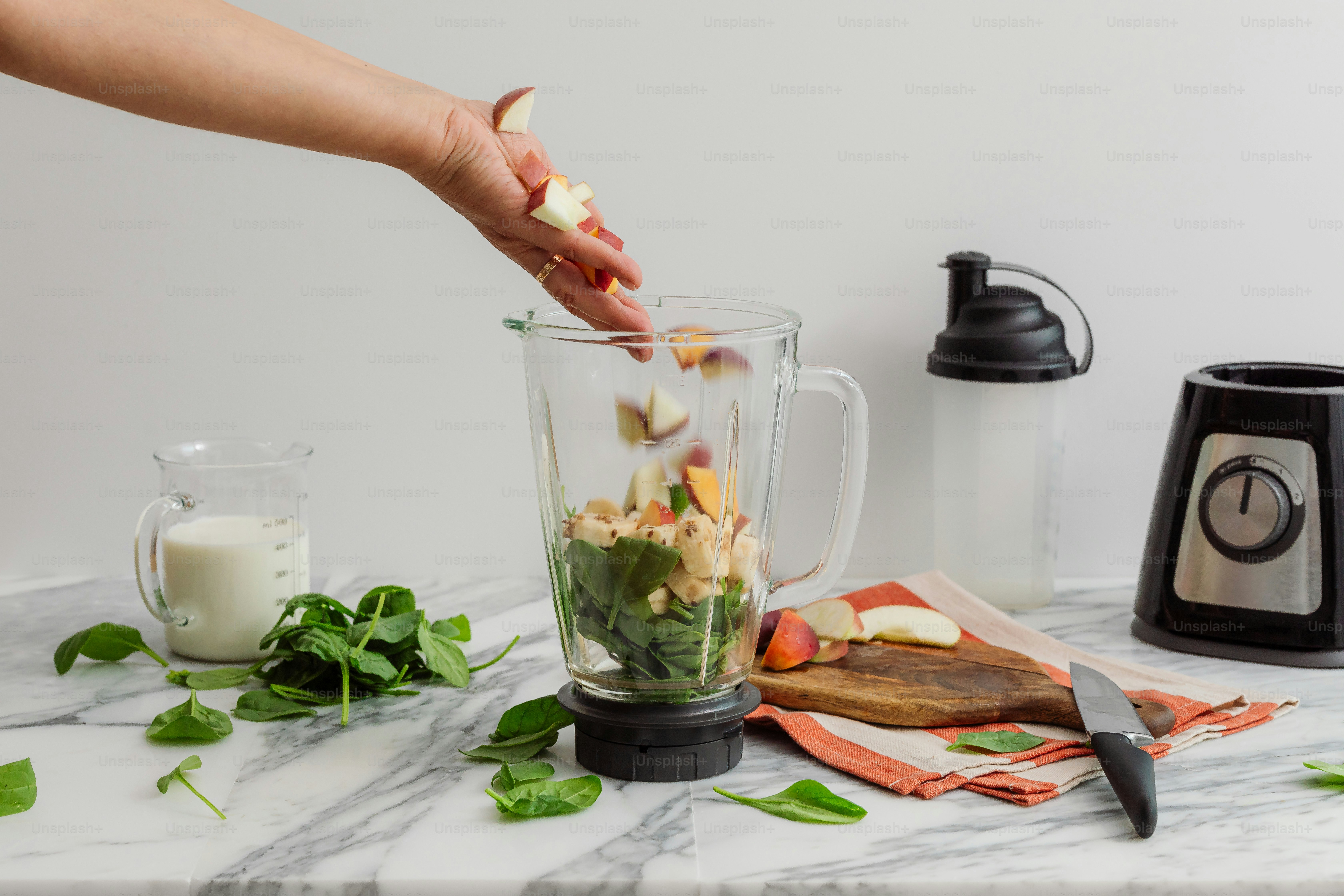 A person adding ingredients to a blender