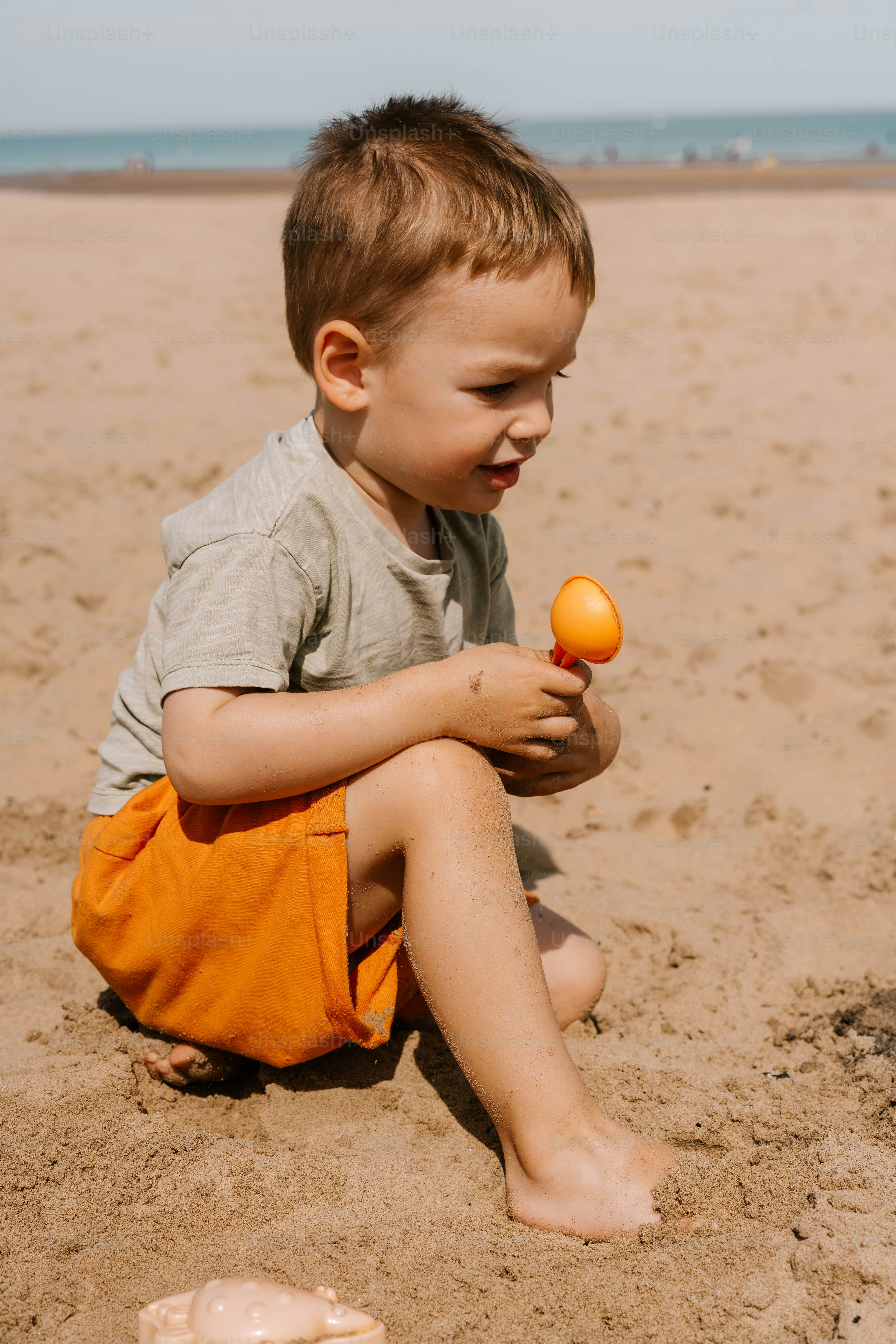 A little boy that is sitting in the sand
