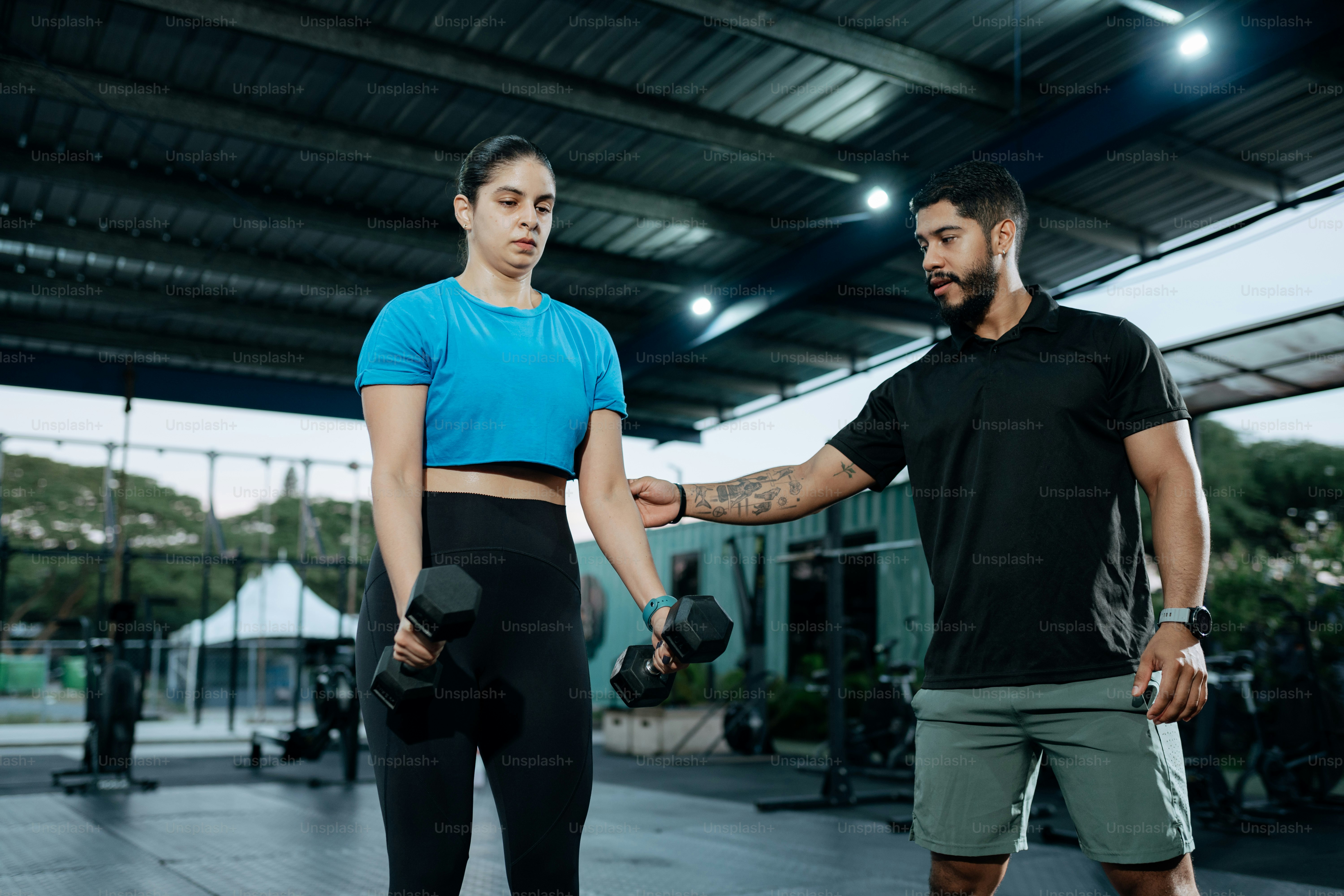 Un hombre de pie junto a una mujer en un gimnasio