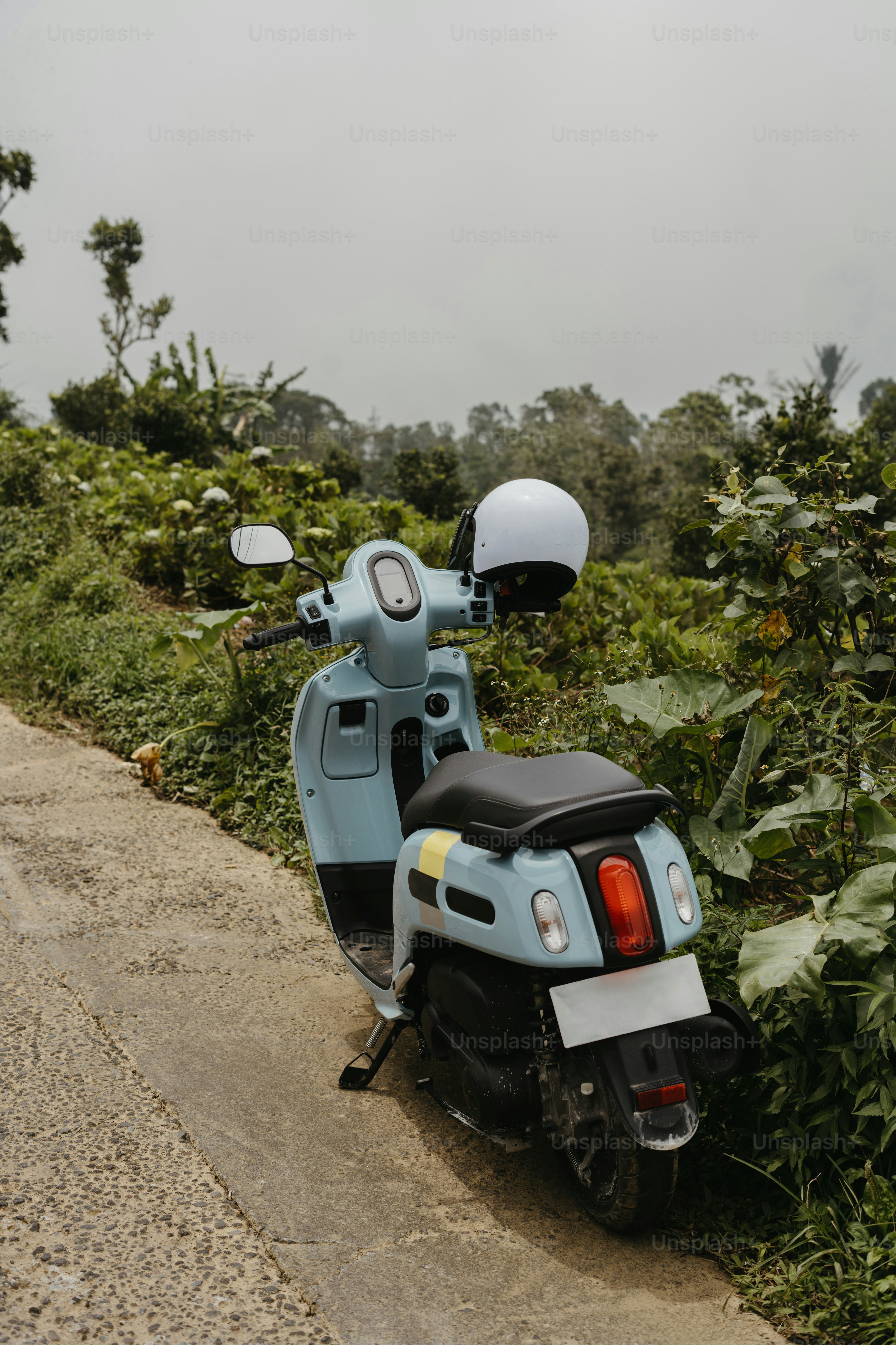 A blue scooter parked on the side of a road