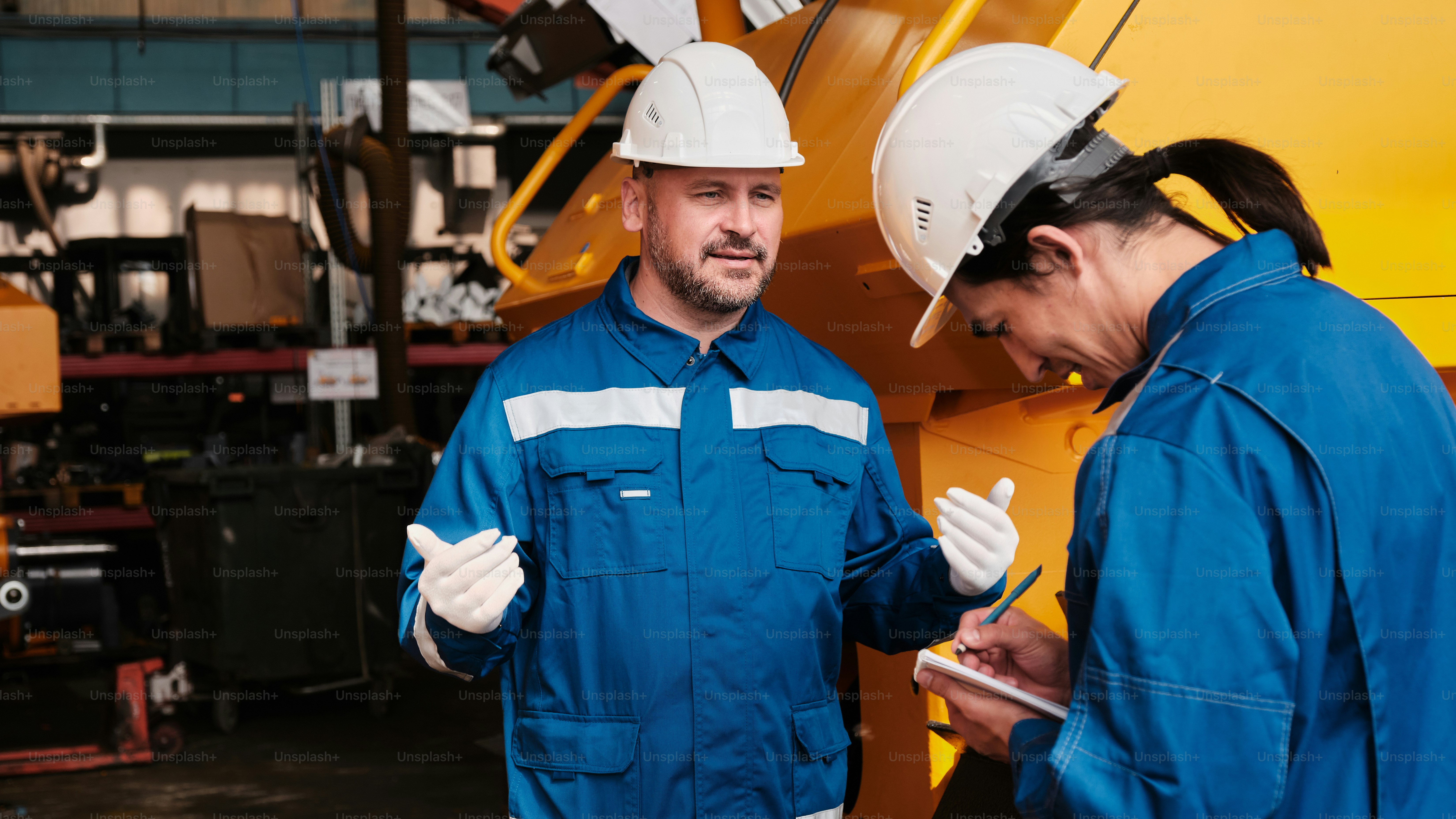 Two men in blue work clothes in a factory