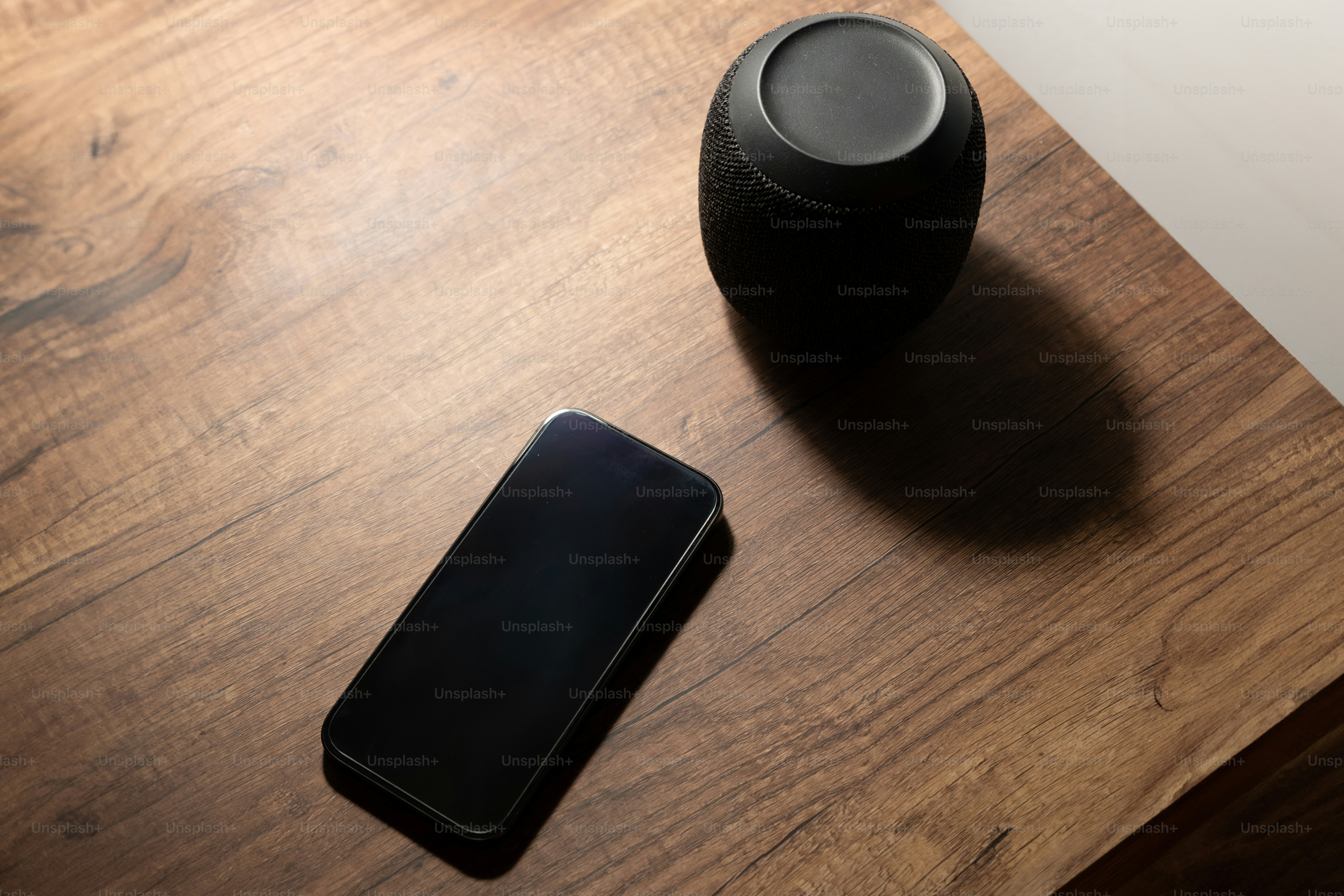 A black speaker sitting on top of a wooden table