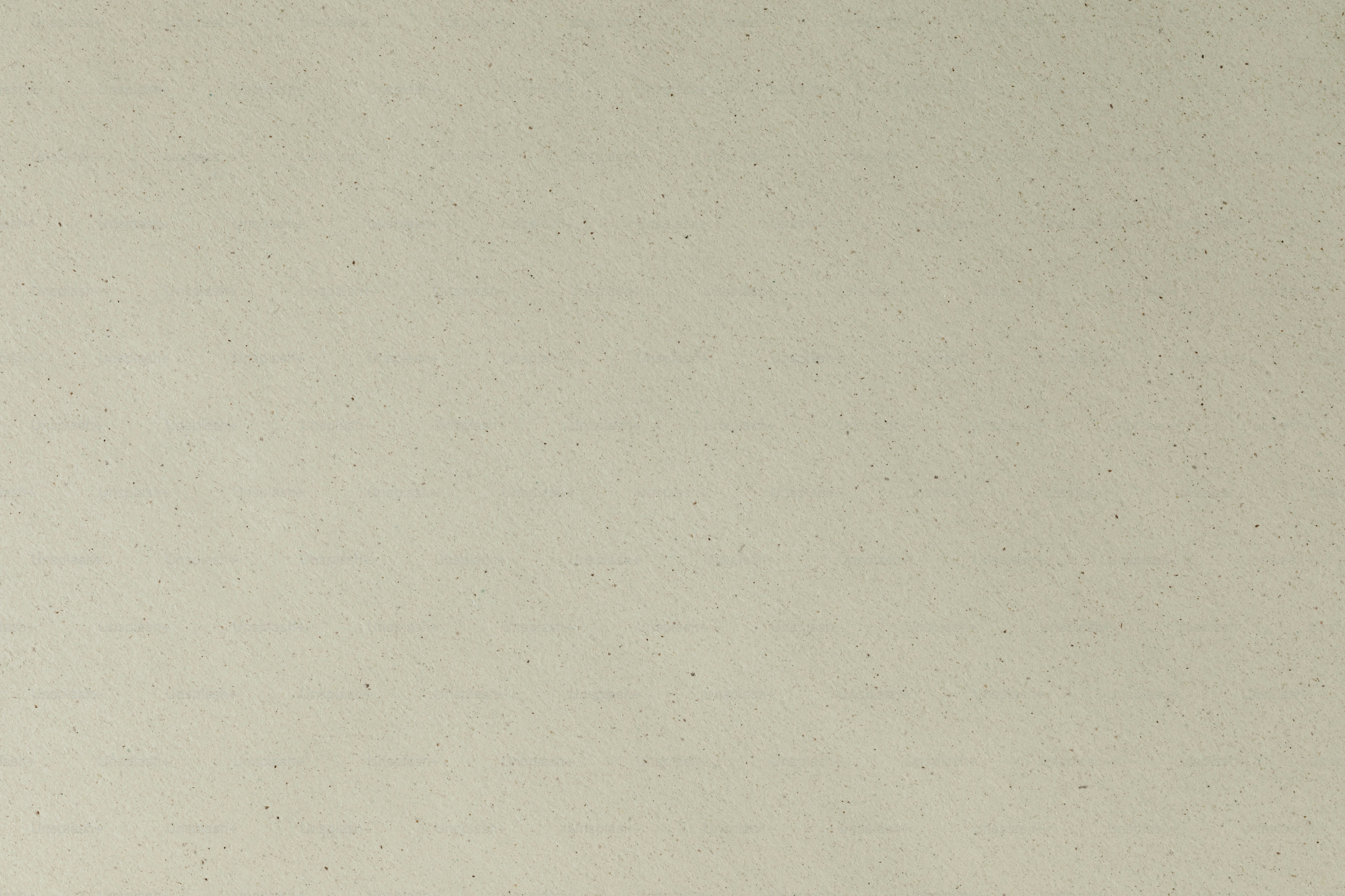 A man in a suit and tie standing in front of a white wall