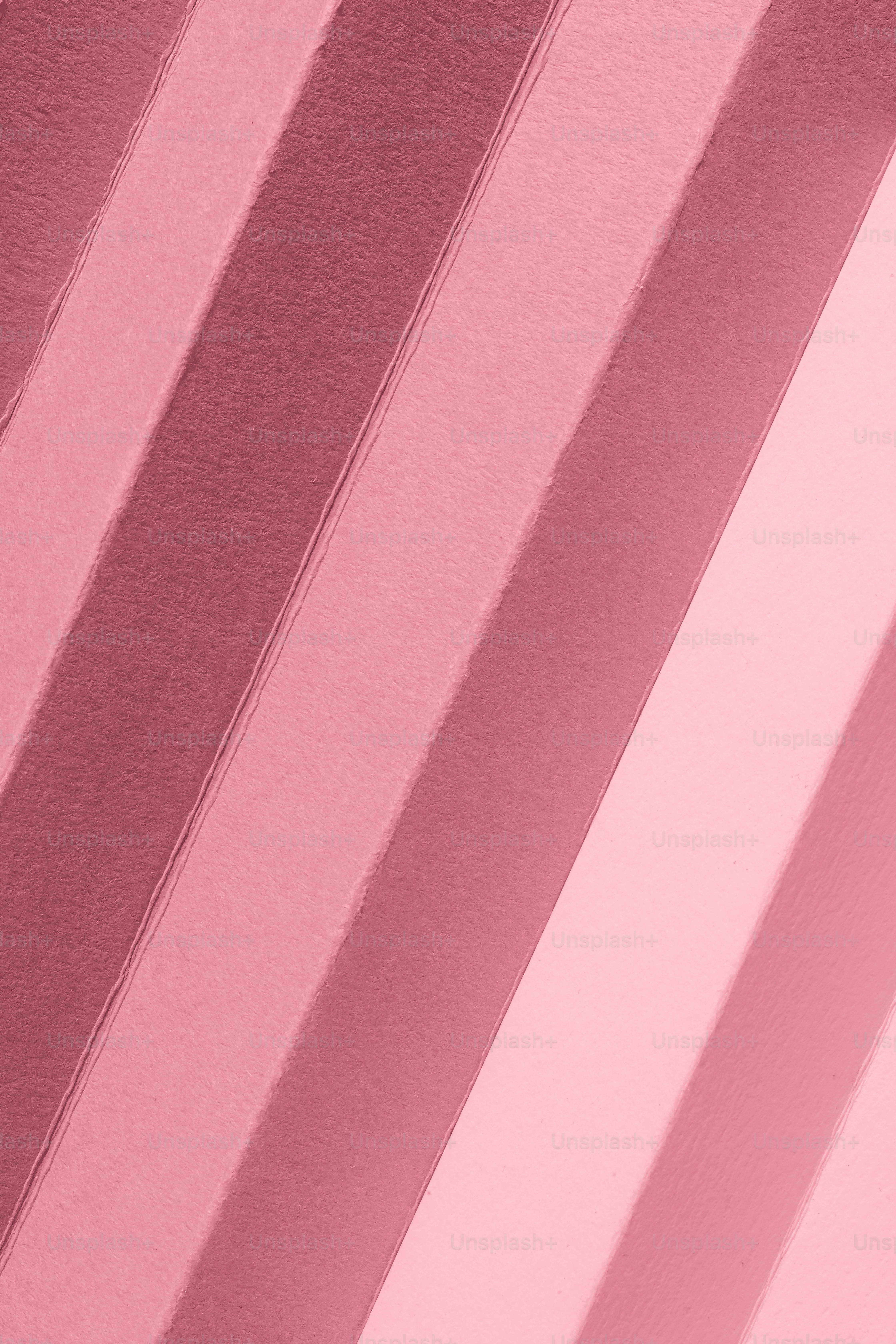 Un gros plan d’un mur rose avec des lignes verticales