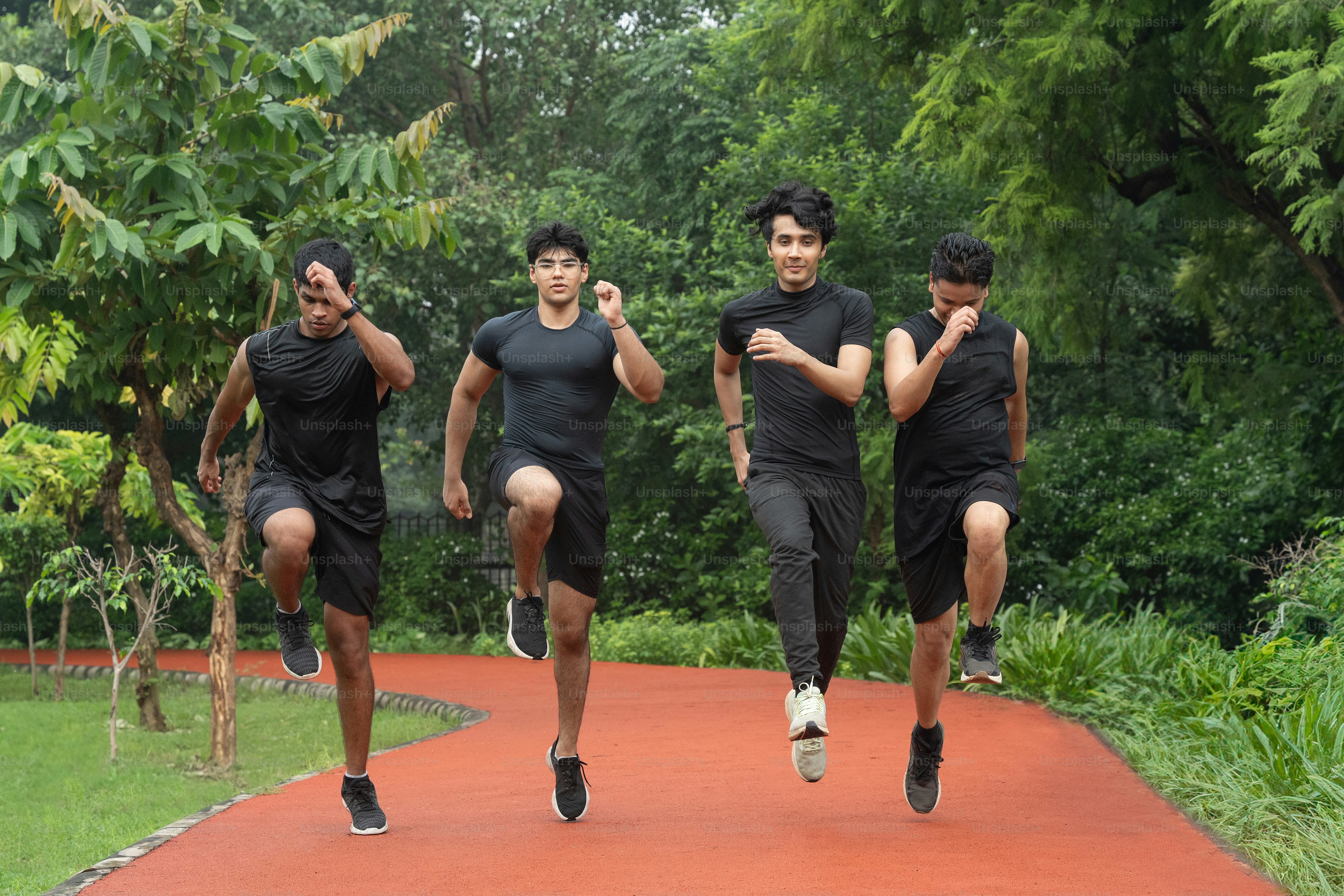 A group of runners hopping and streatching before running on the track.