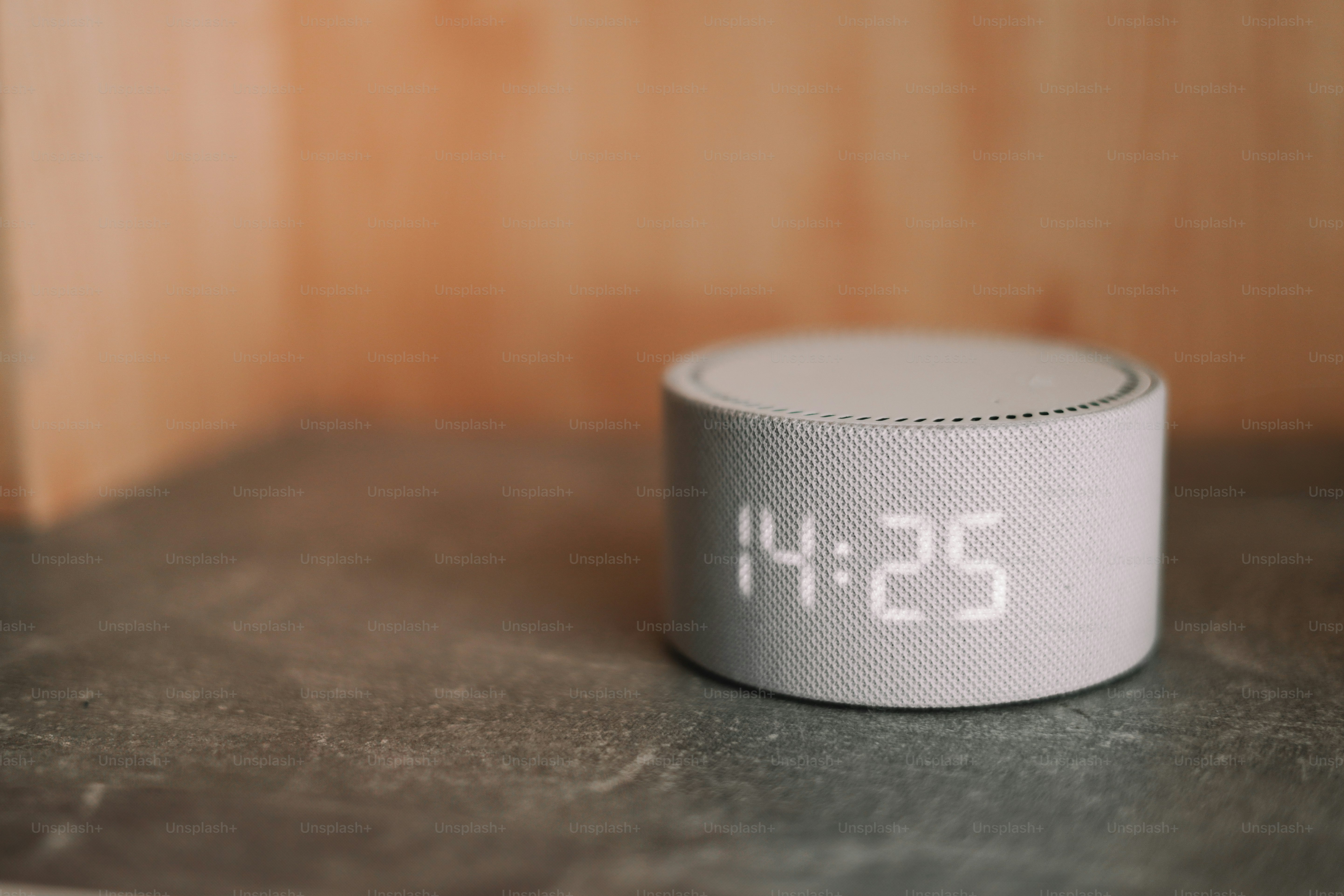 A white alarm clock sitting on top of a table
