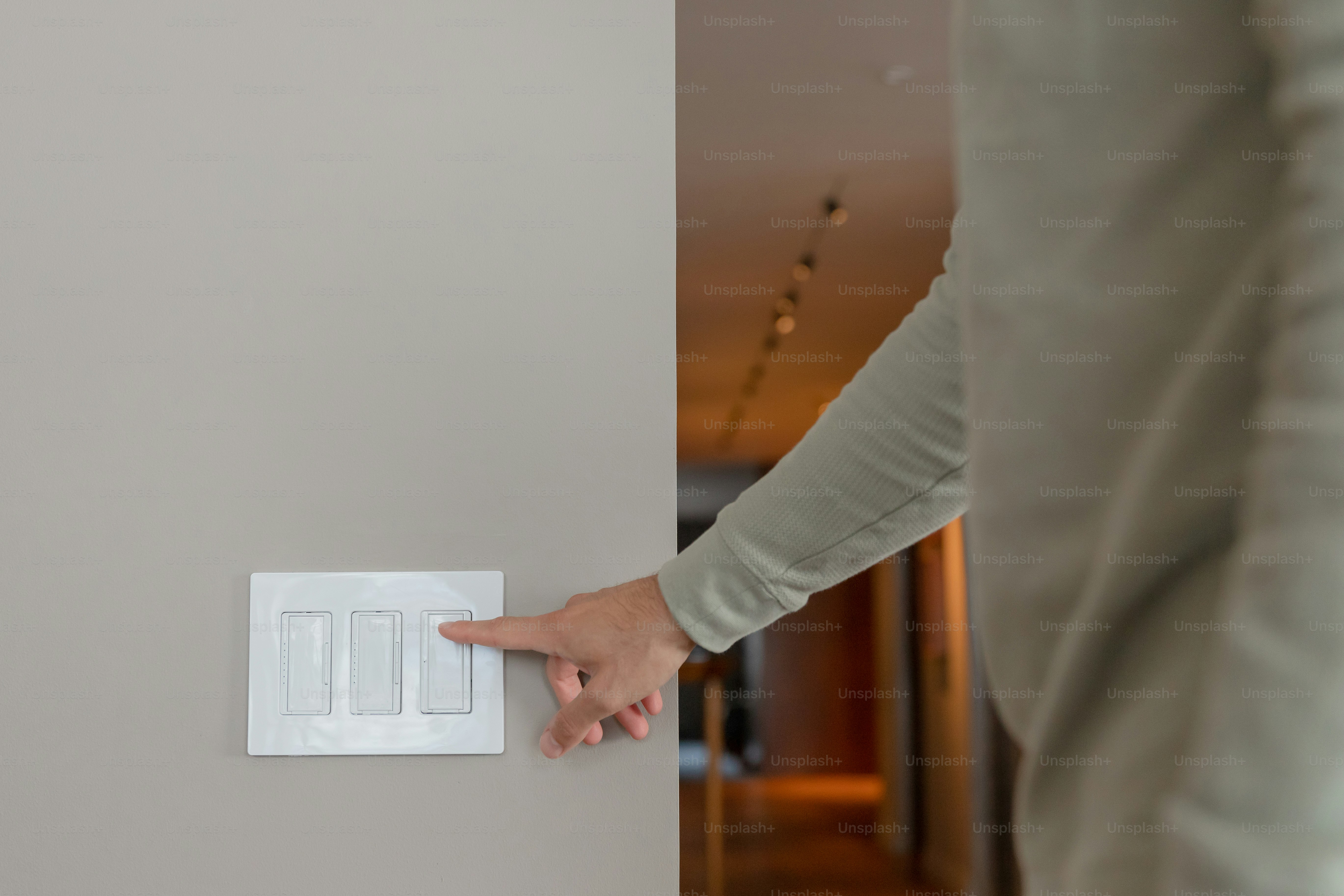 Una persona señalando un interruptor de luz en una pared