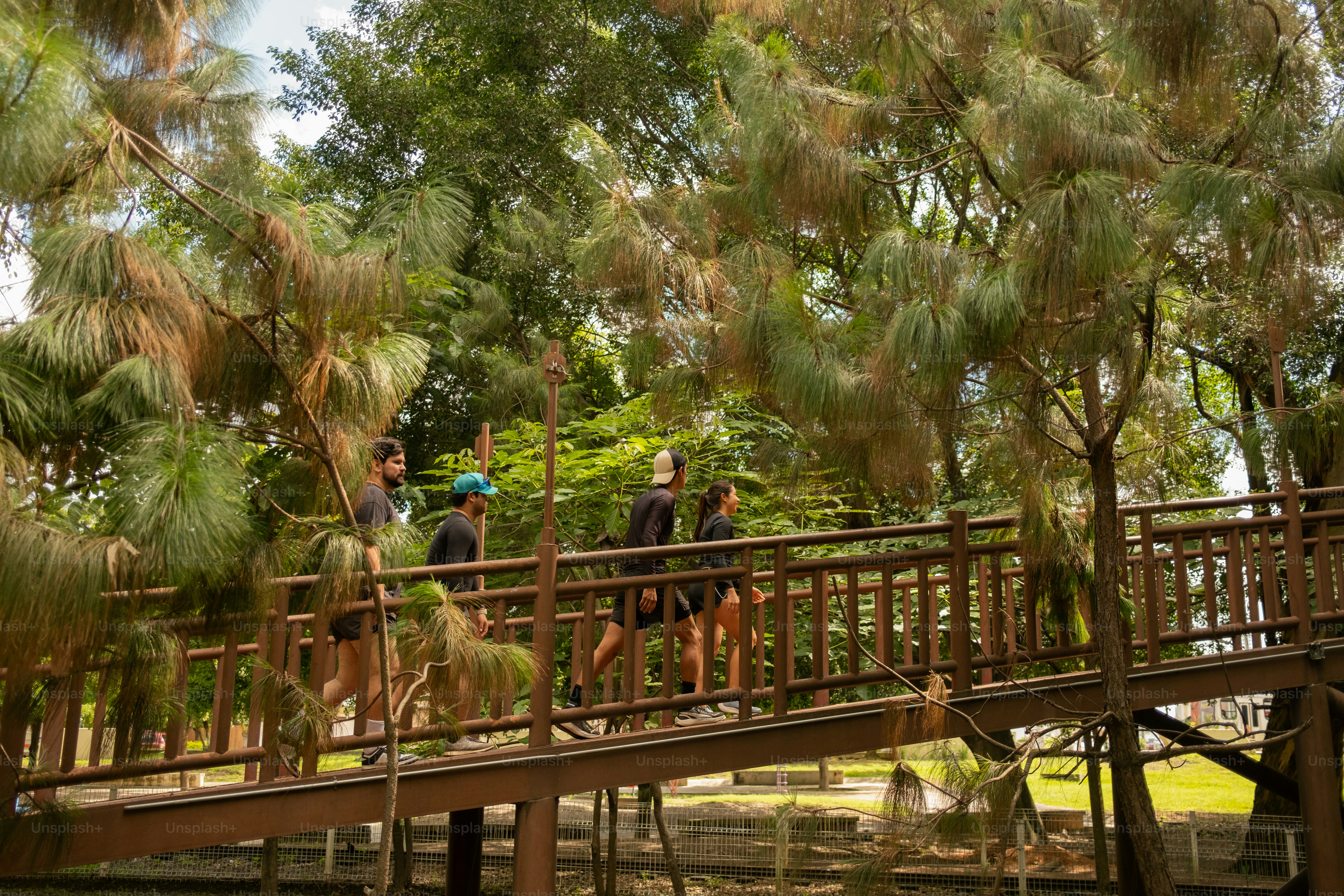 A group of people walking across a wooden bridge