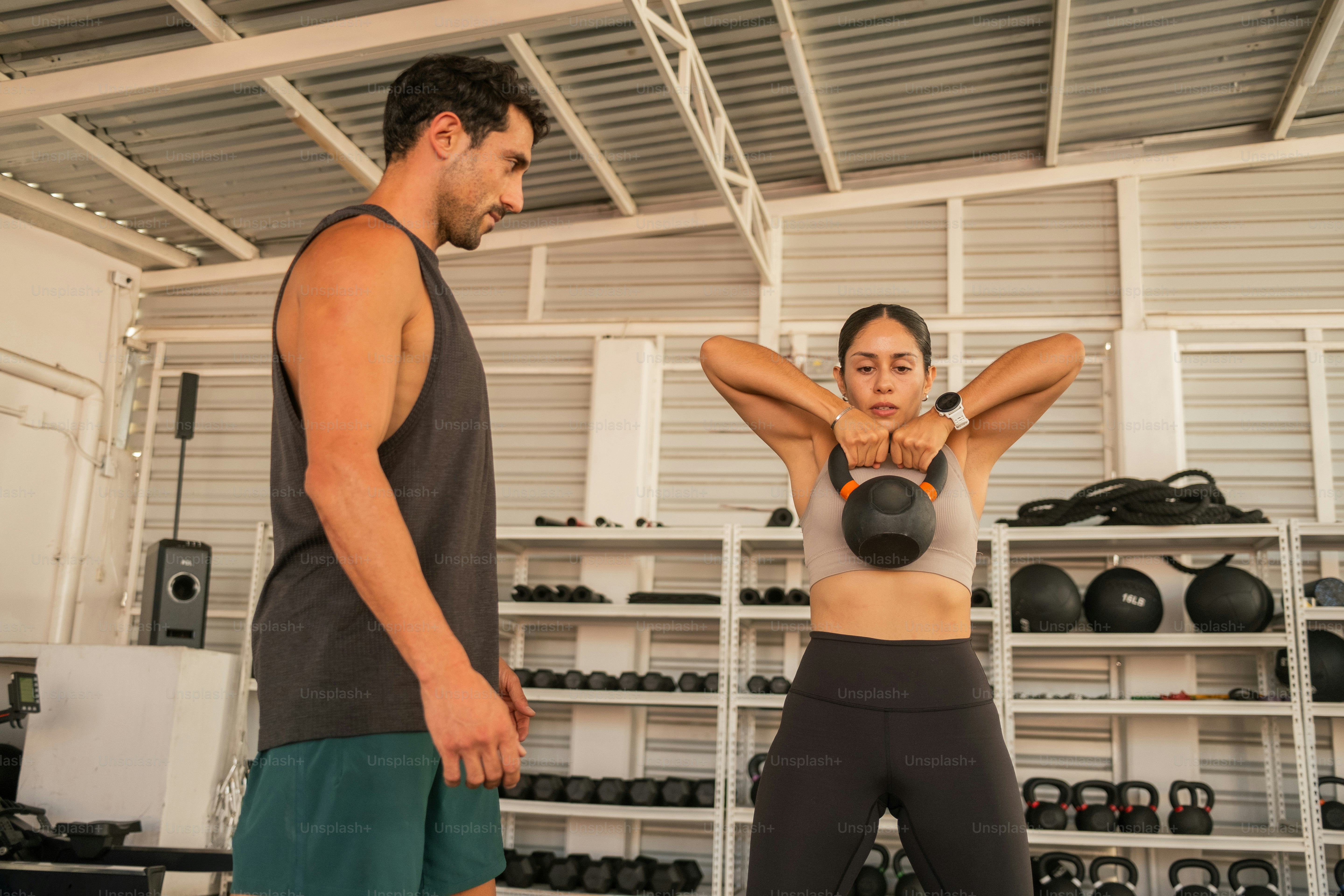 Ein Mann und eine Frau in einer Turnhalle mit Wasserkochern