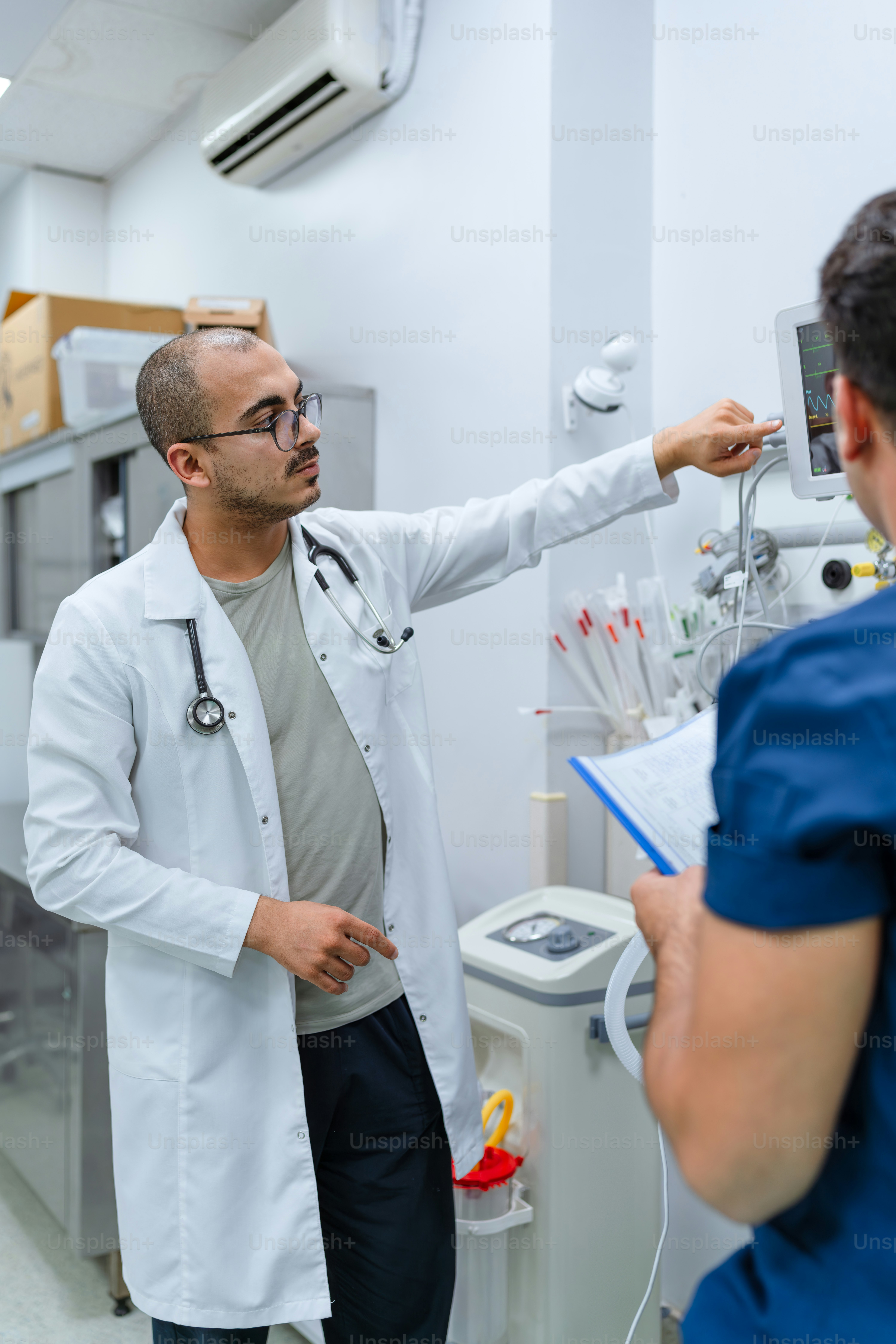 A man in a white lab coat pointing at something