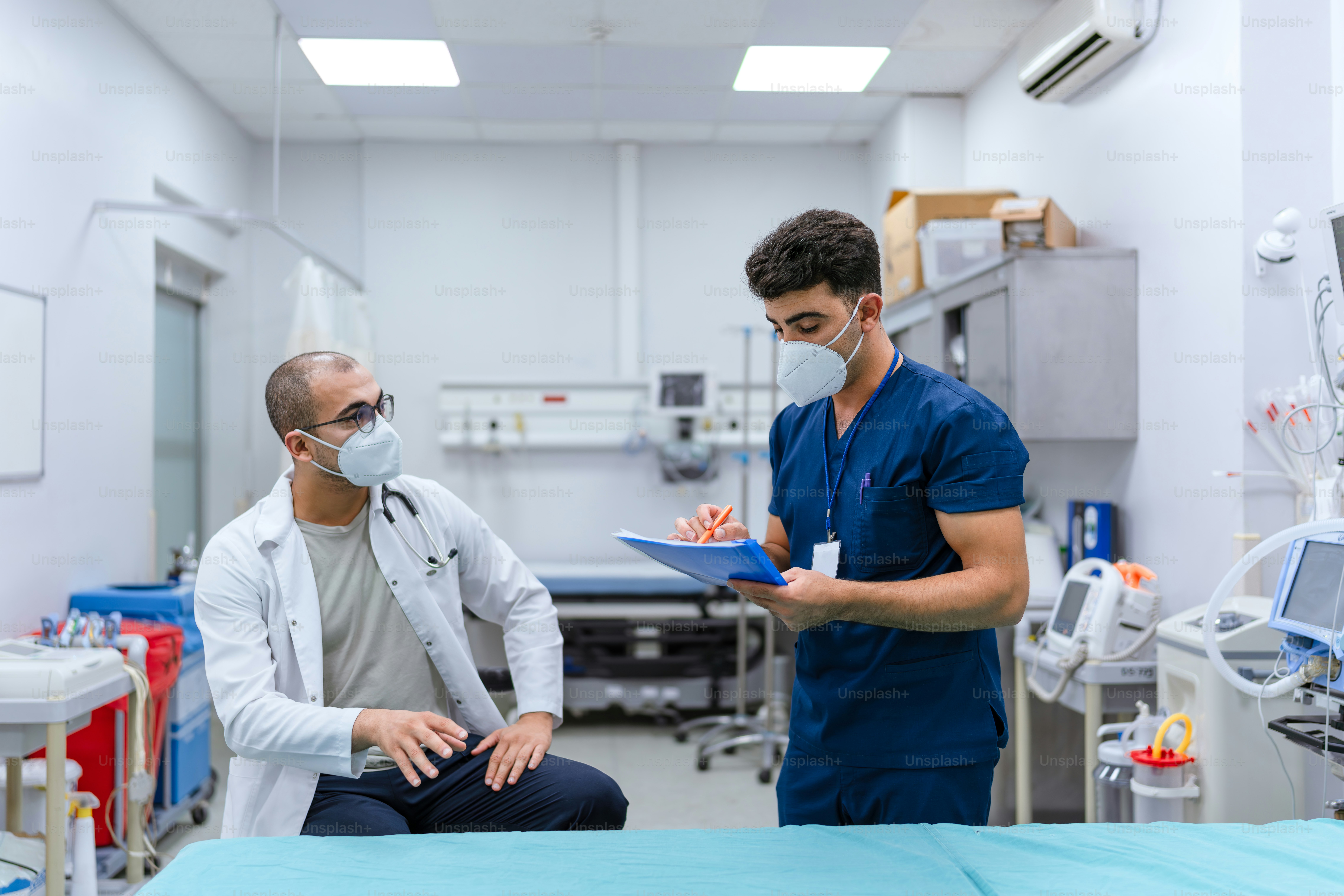 Two men in a hospital room with medical equipment