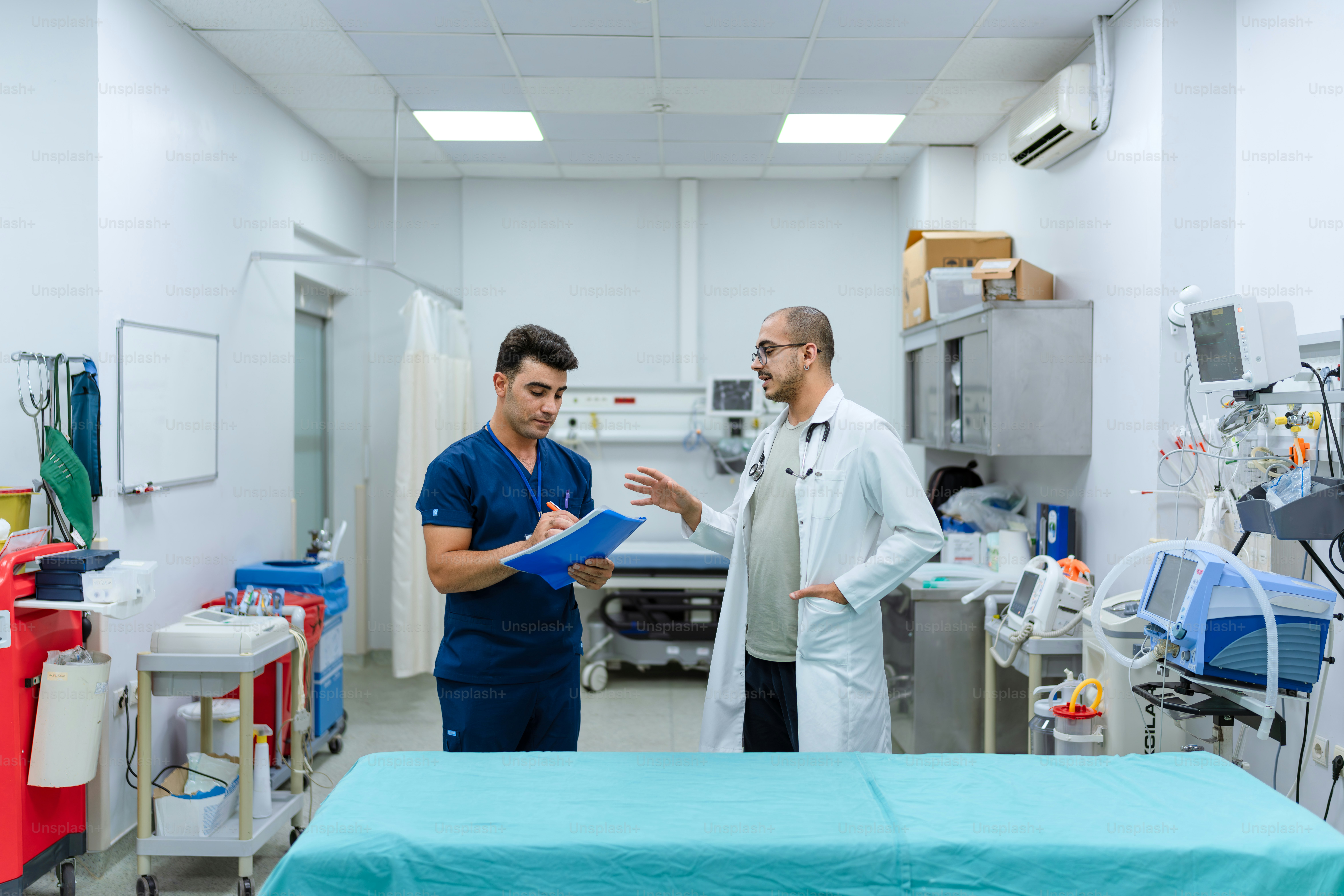 A couple of men standing in a hospital room