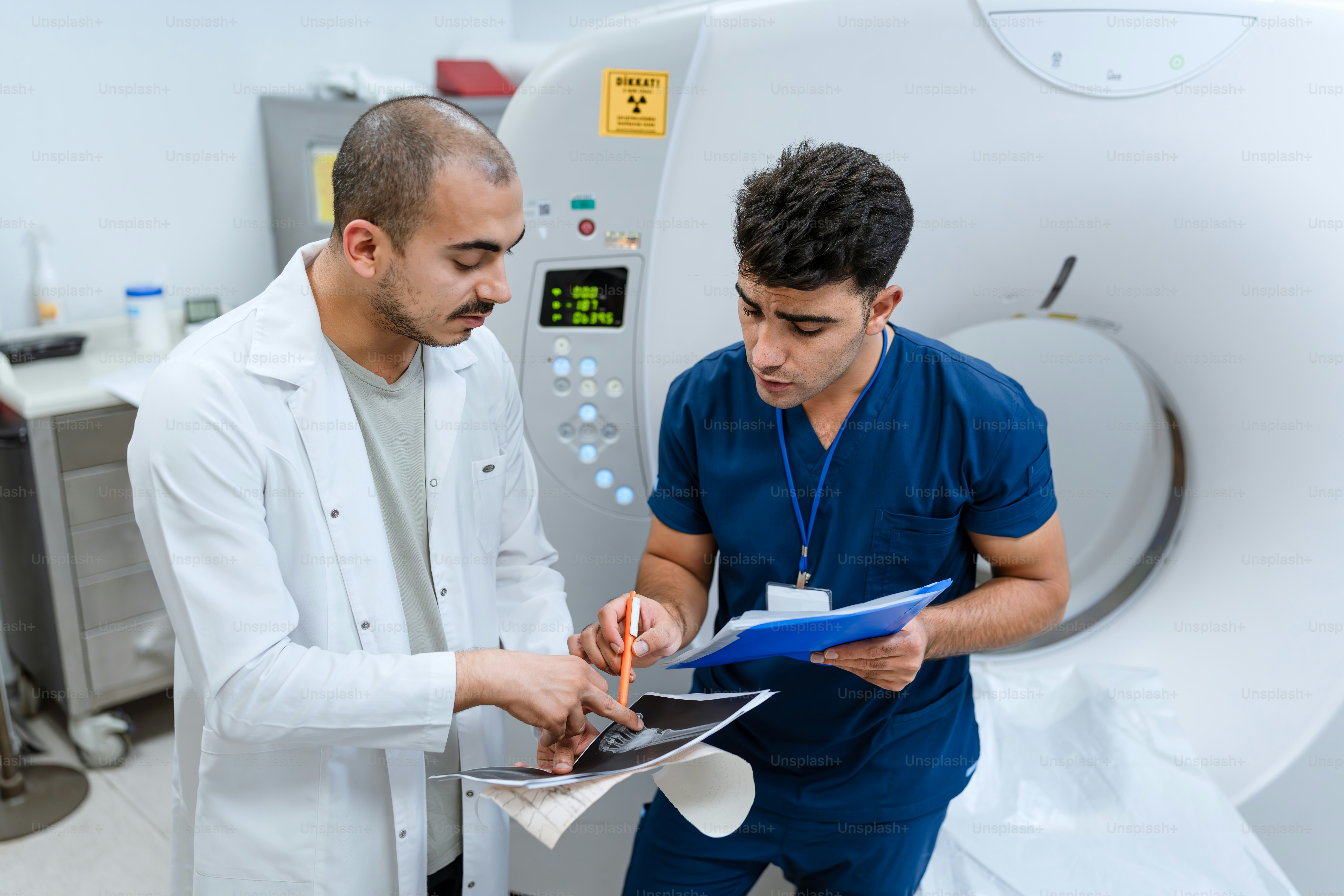 Two men in white lab coats looking at a piece of paper