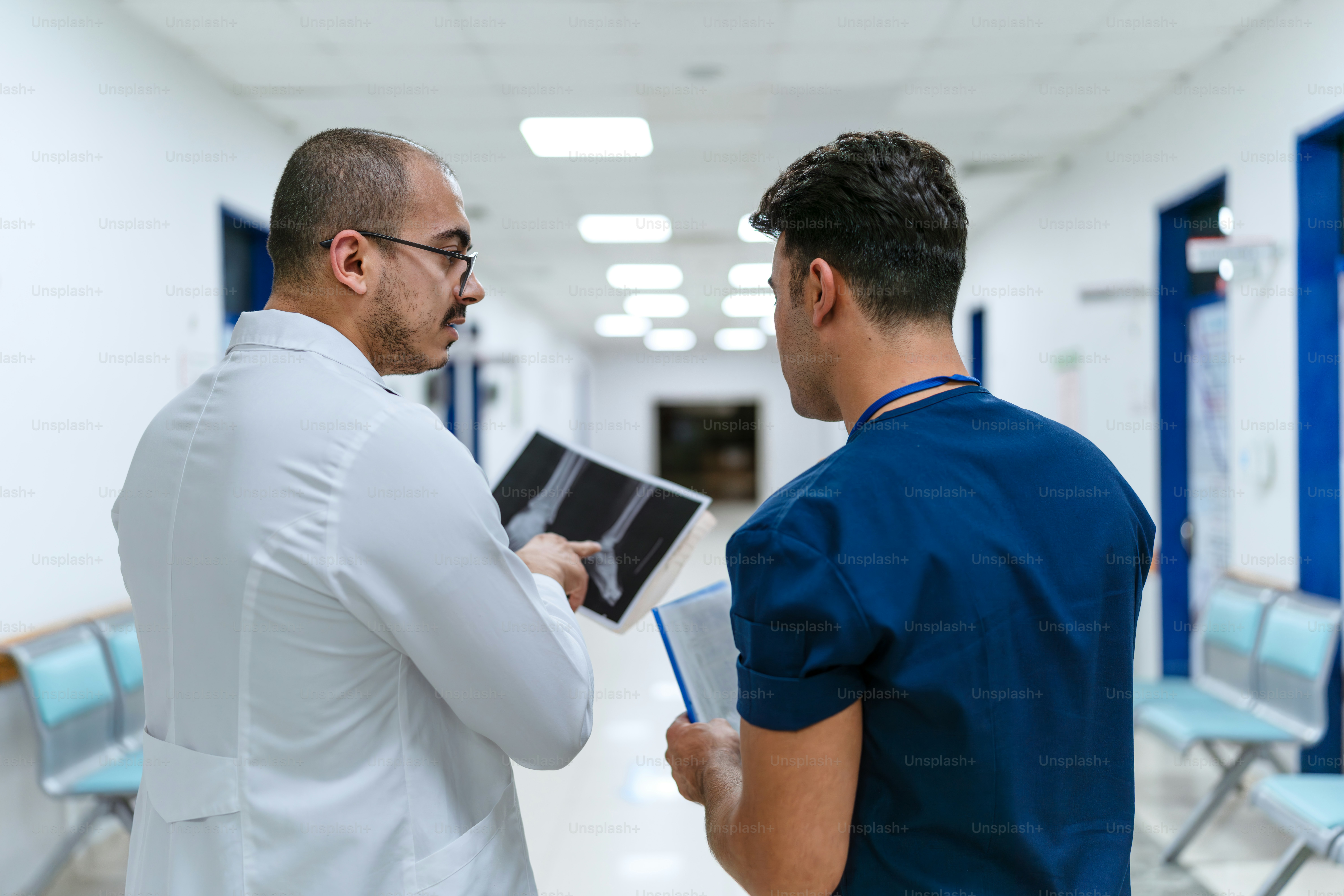 Two men in scrubs are talking to each other