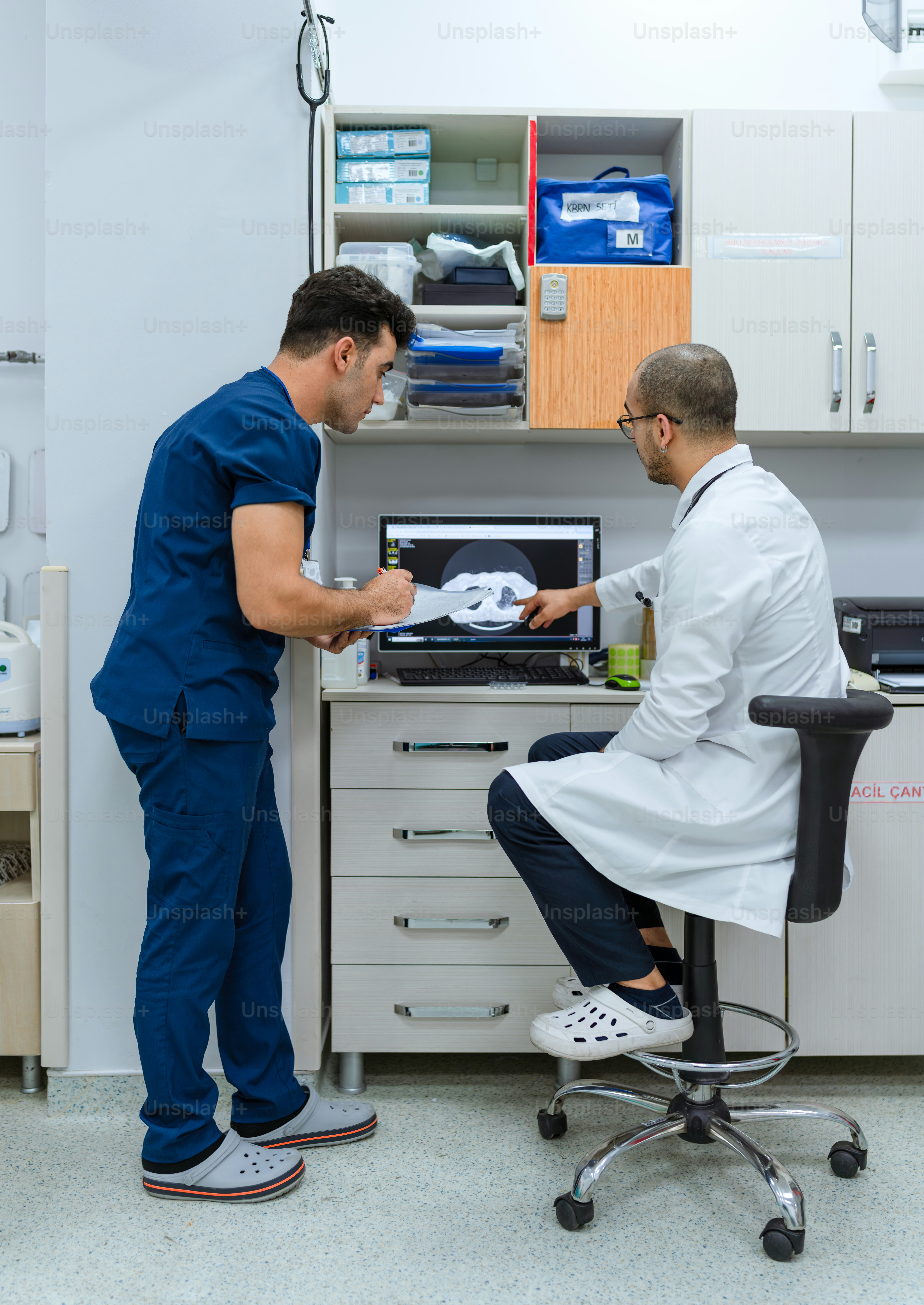 A man in a white lab coat standing next to a man in a white lab