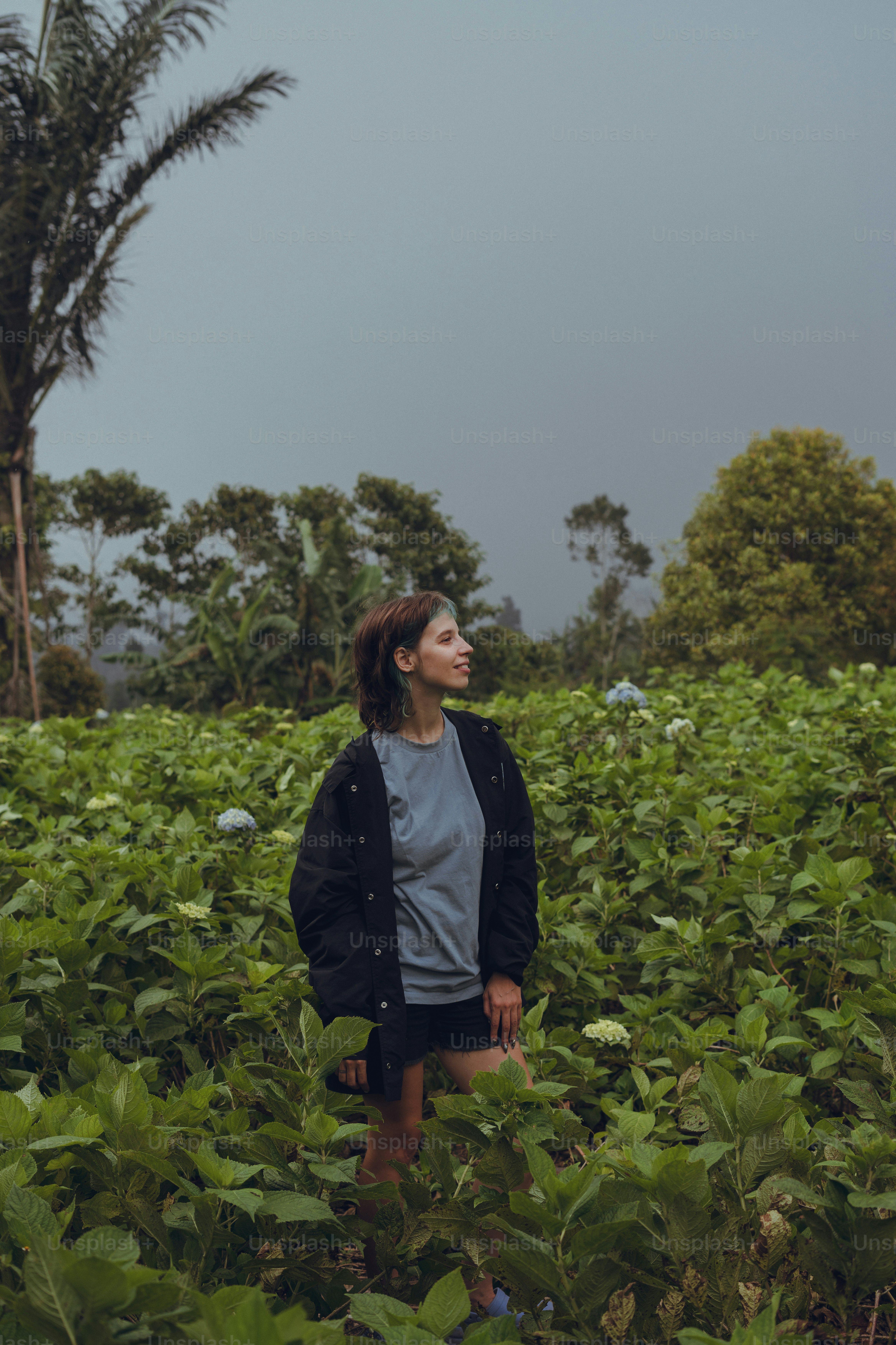 A woman standing in a field of green plants