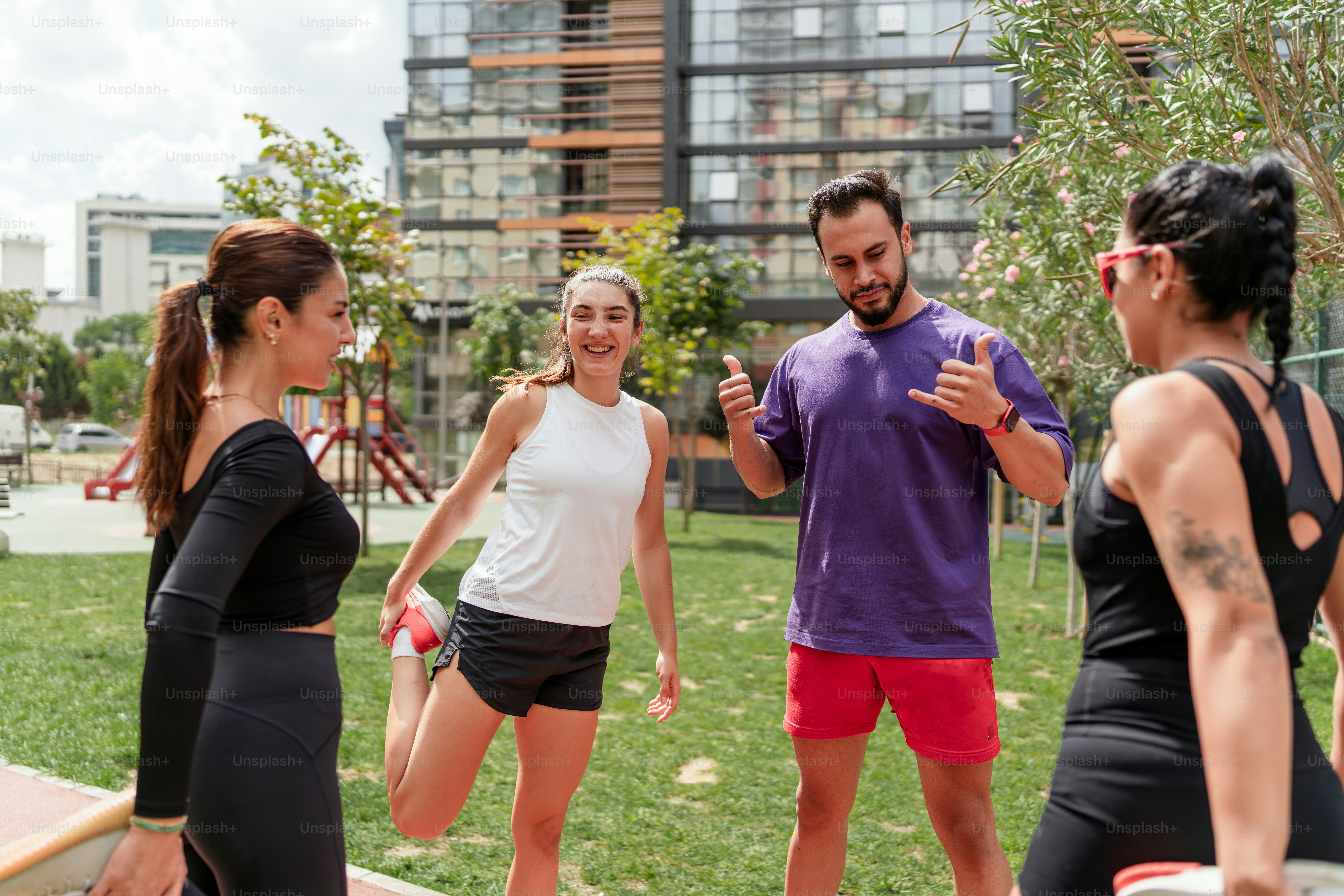 A group of people standing around each other in a park