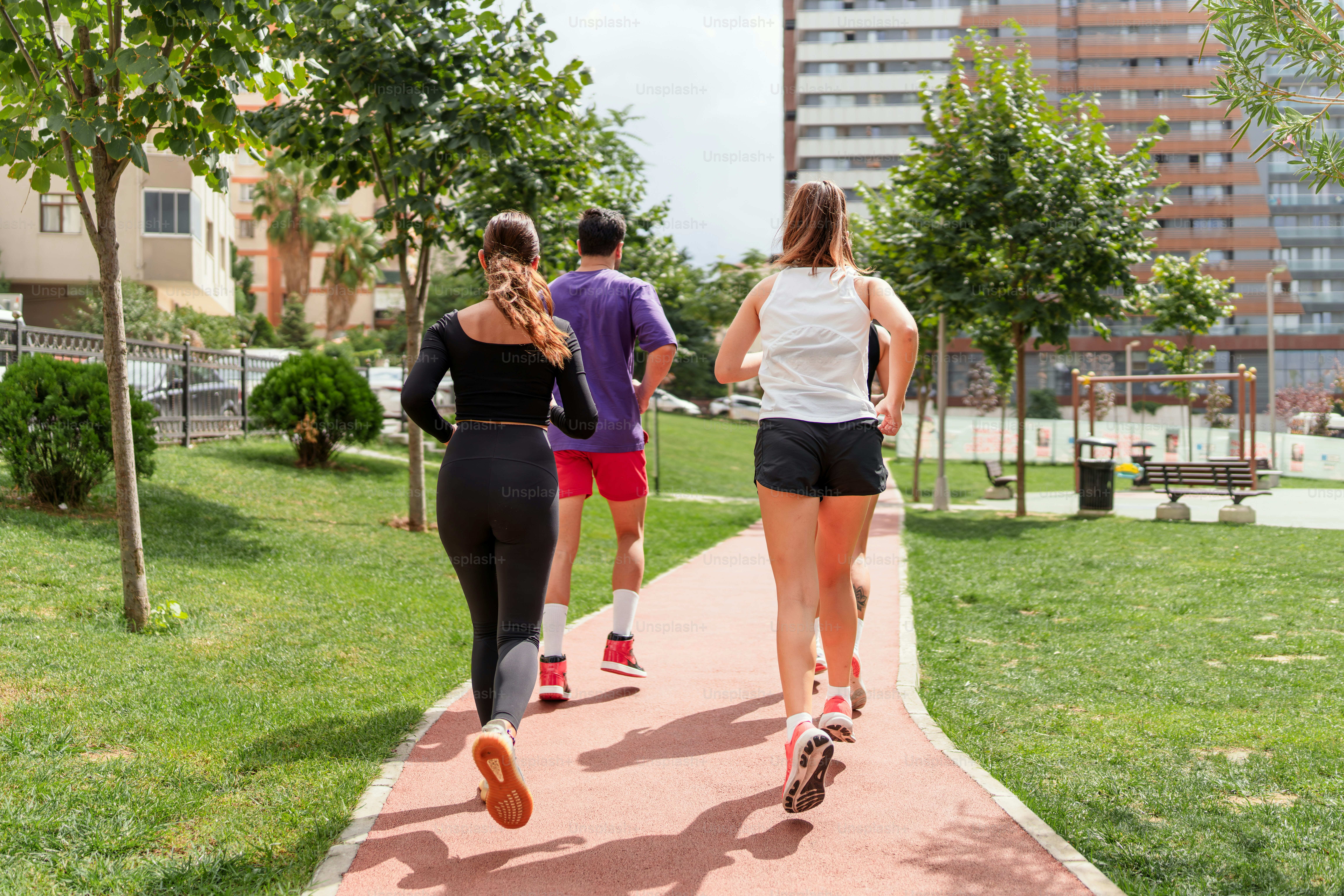 A group of people that are walking down a sidewalk