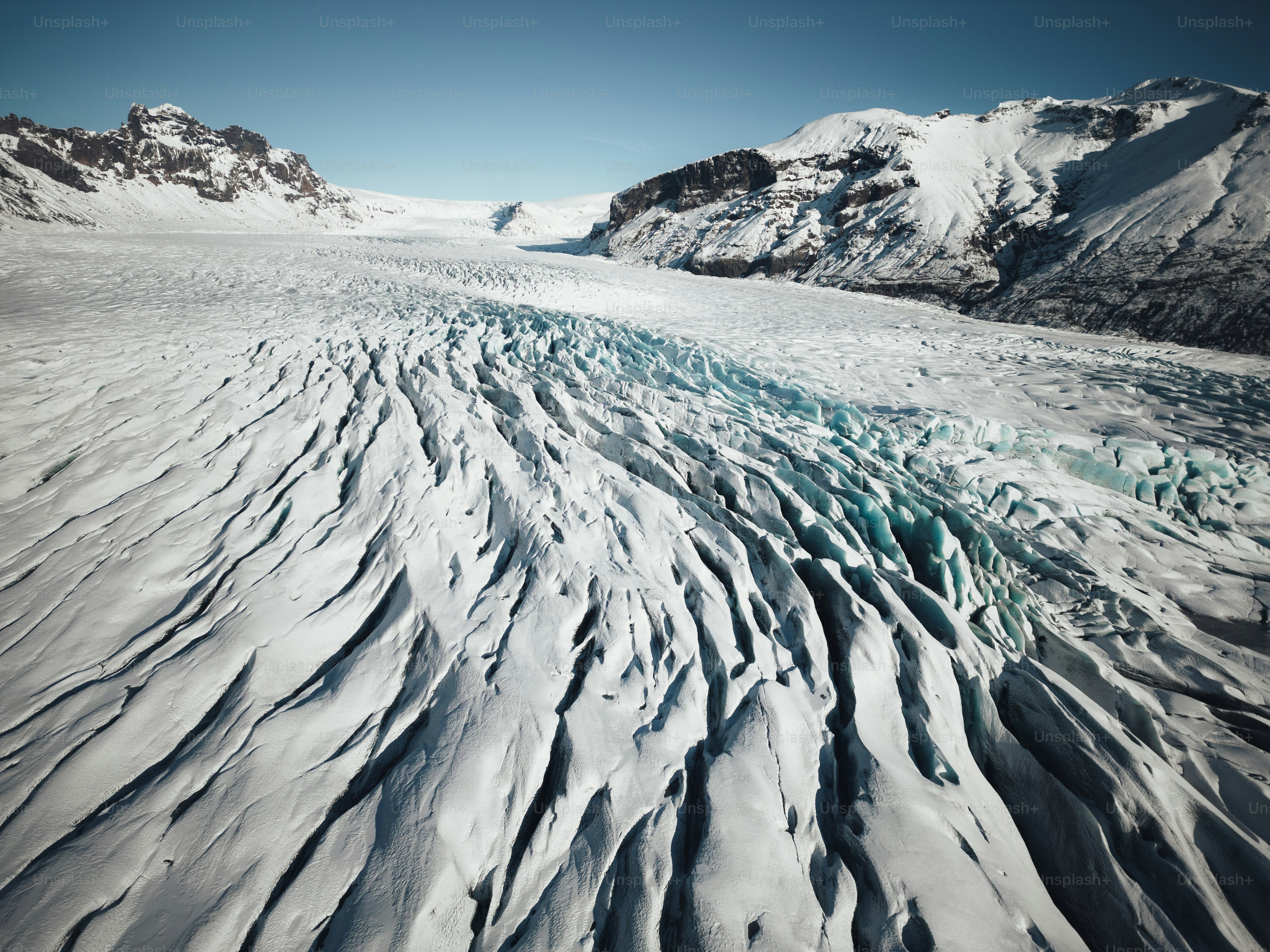 A large expanse of snow with mountains in the background
