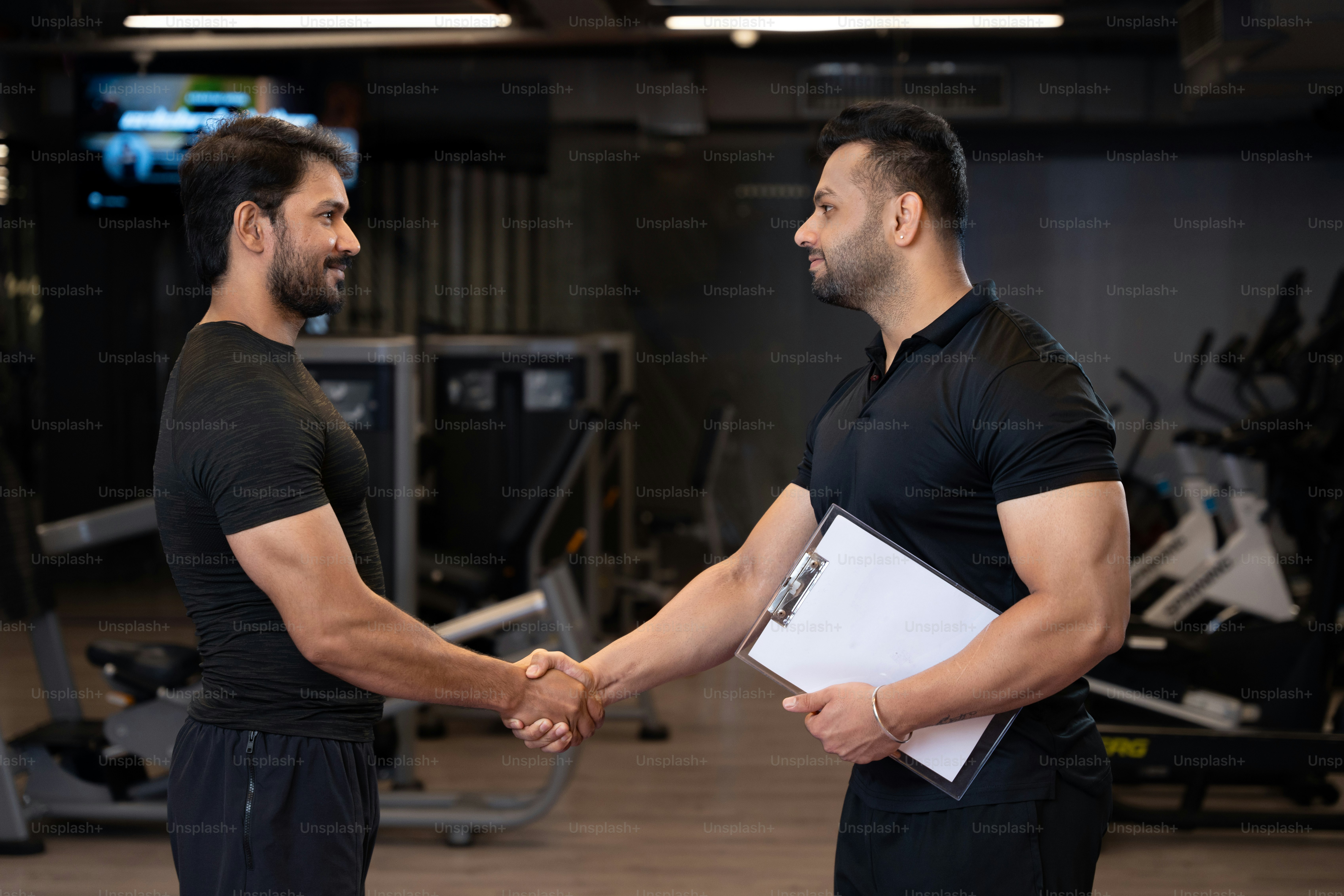 Two men shaking hands in a gym