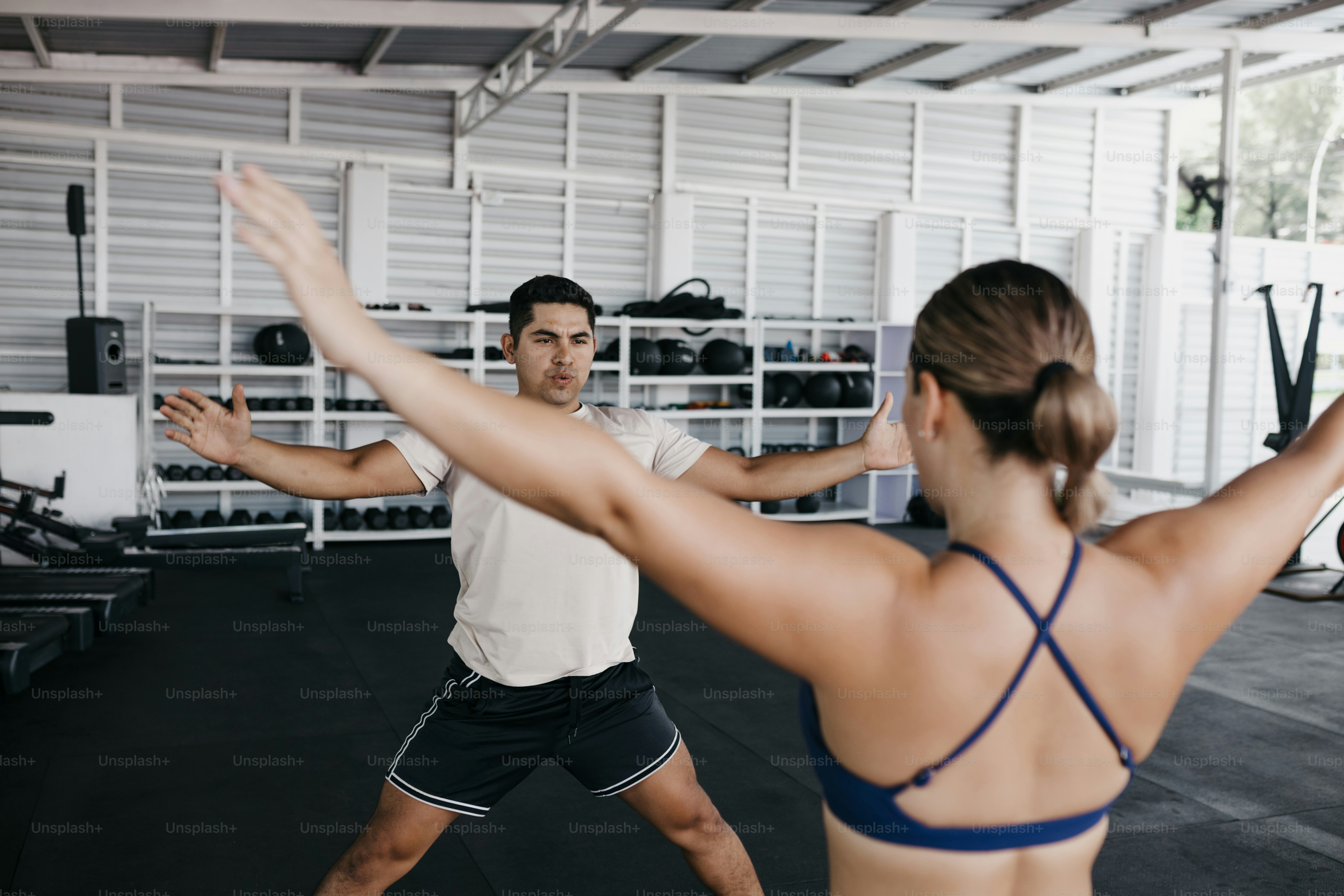 A man and a woman doing exercises in a gym
