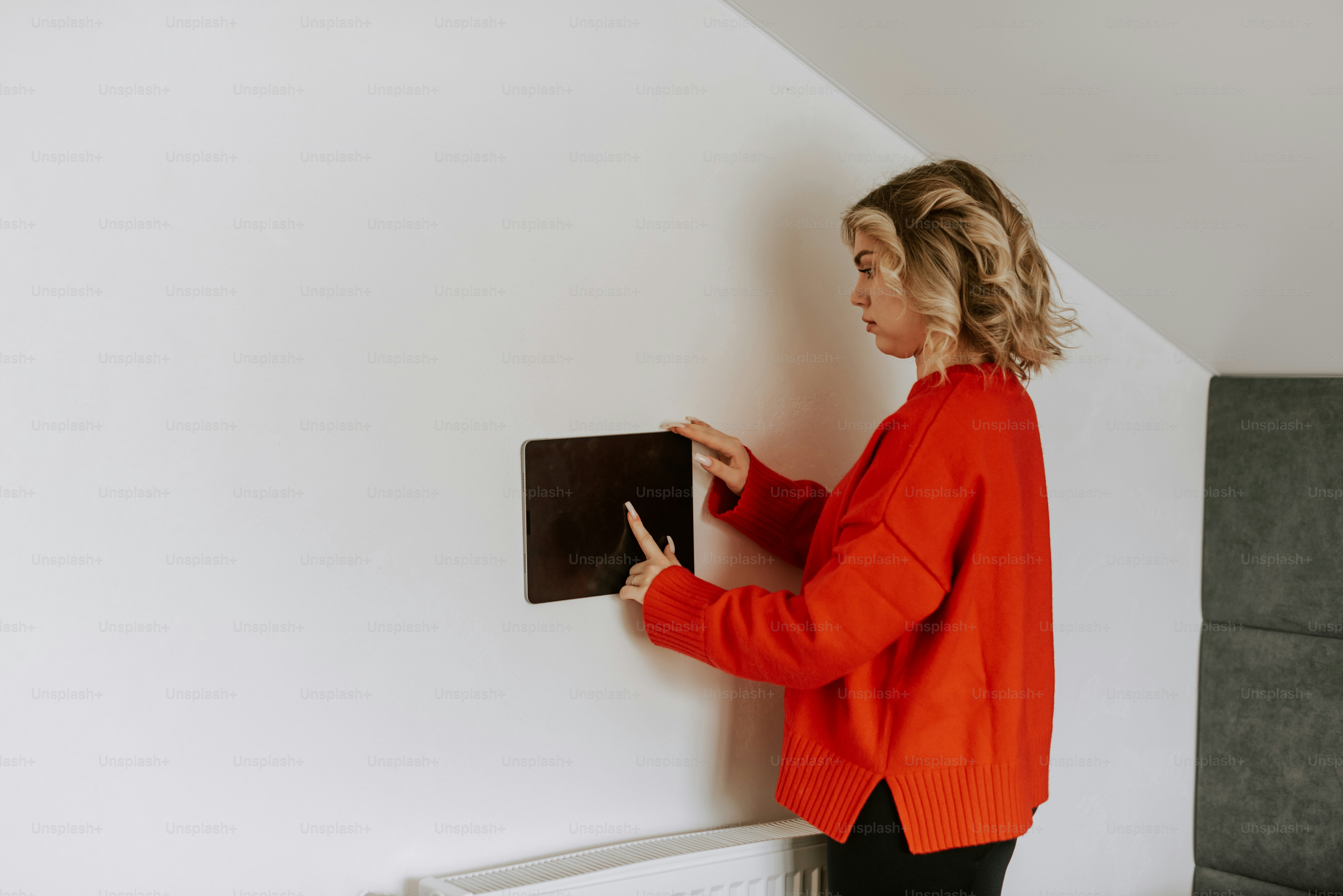 Una mujer con una camisa roja sostiene una computadora portátil