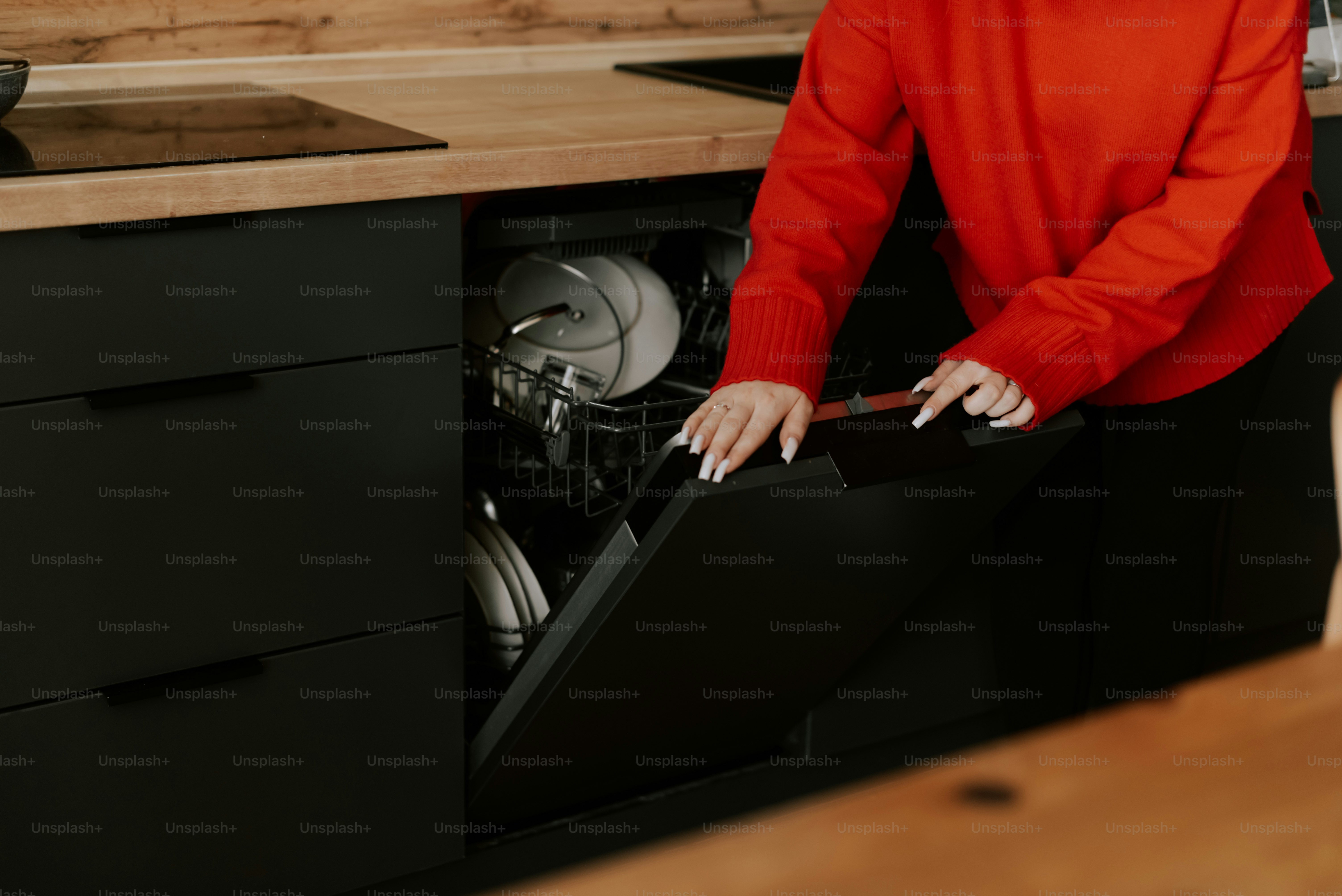 Una mujer con camisa roja abre un lavavajillas