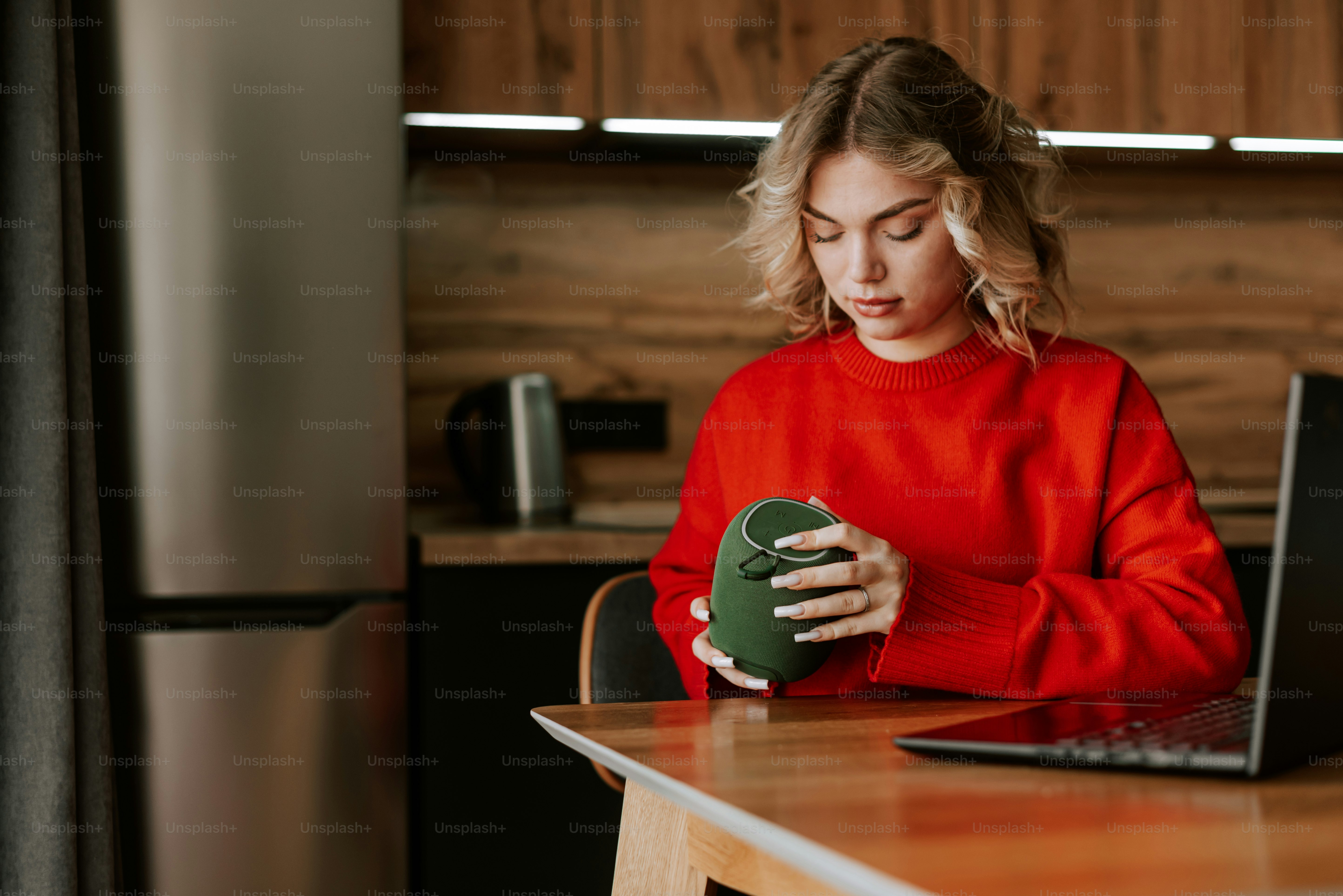Una mujer sentada en la mesa de la cocina con un portátil