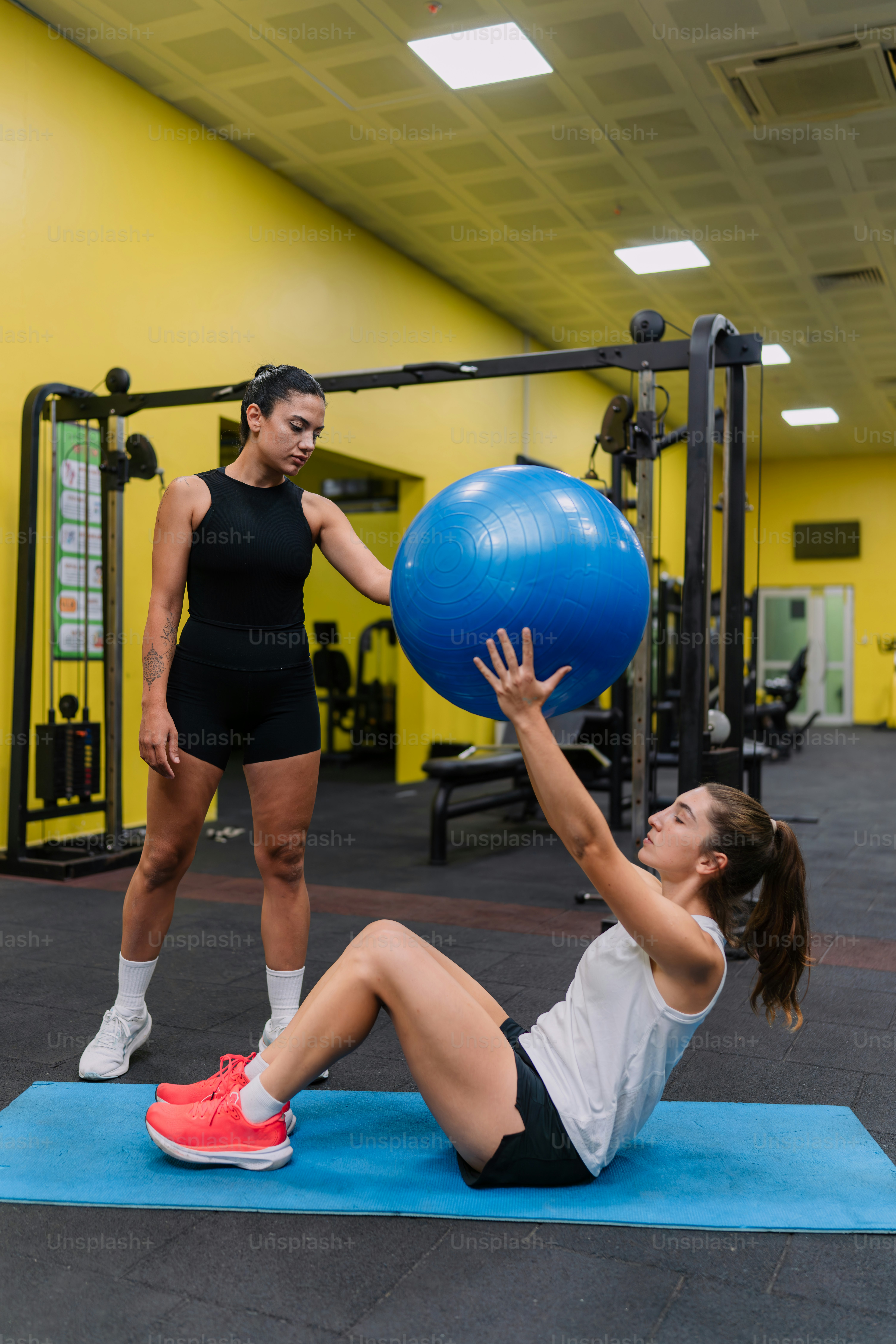 A woman is doing exercises with a blue ball photo – Personal trainer ...