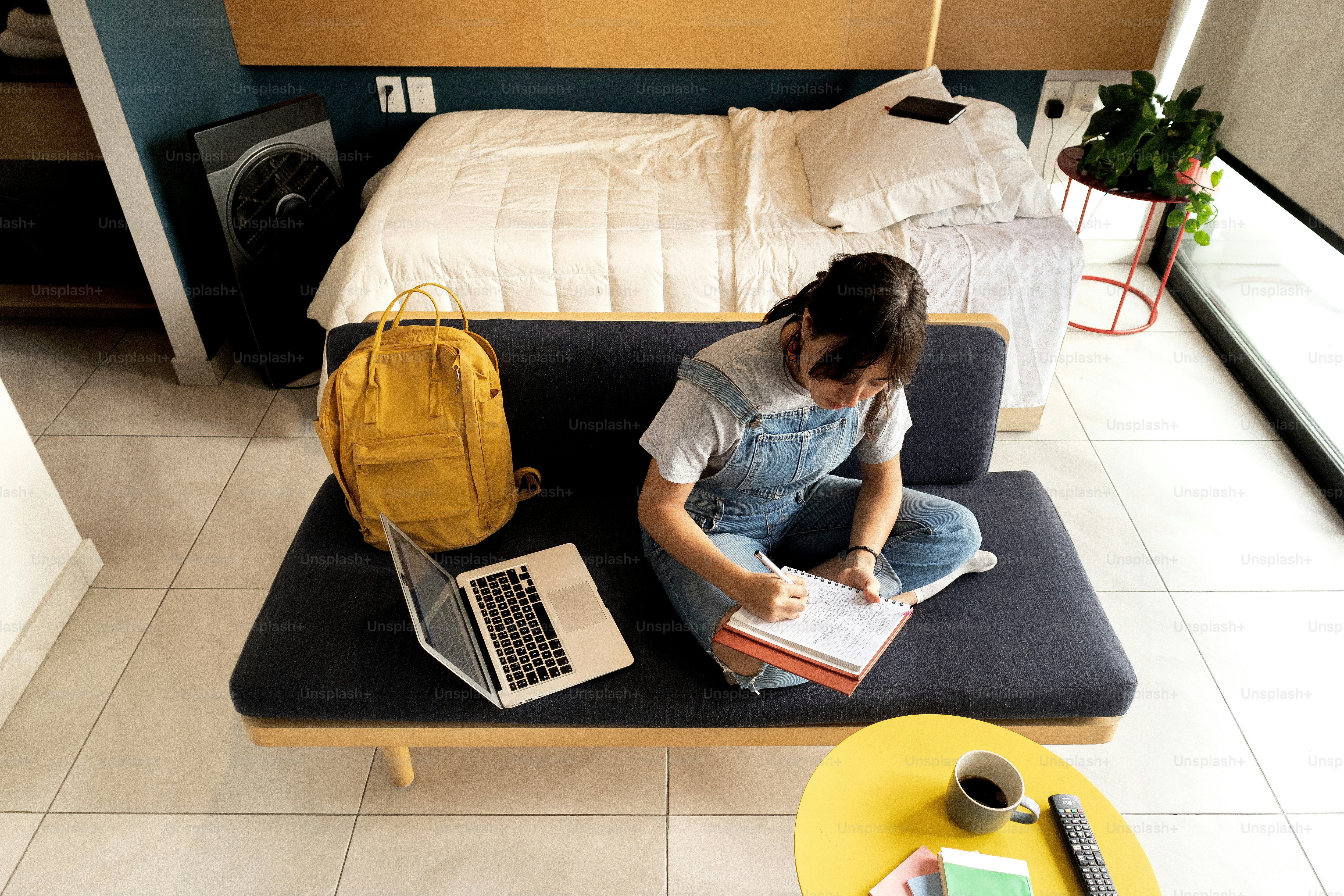 A person sitting on a bed with a laptop