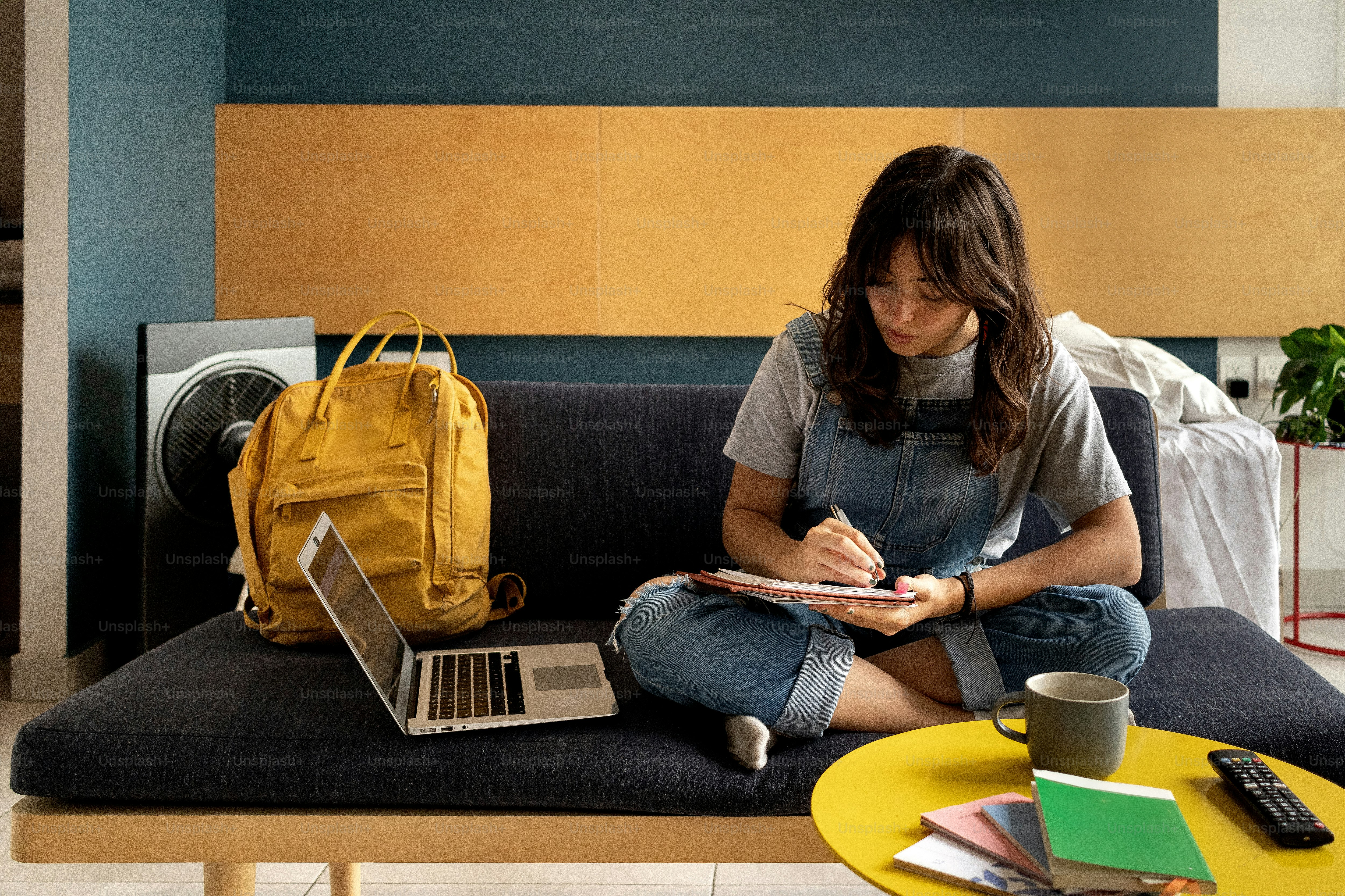 A woman sitting on a couch using a laptop
