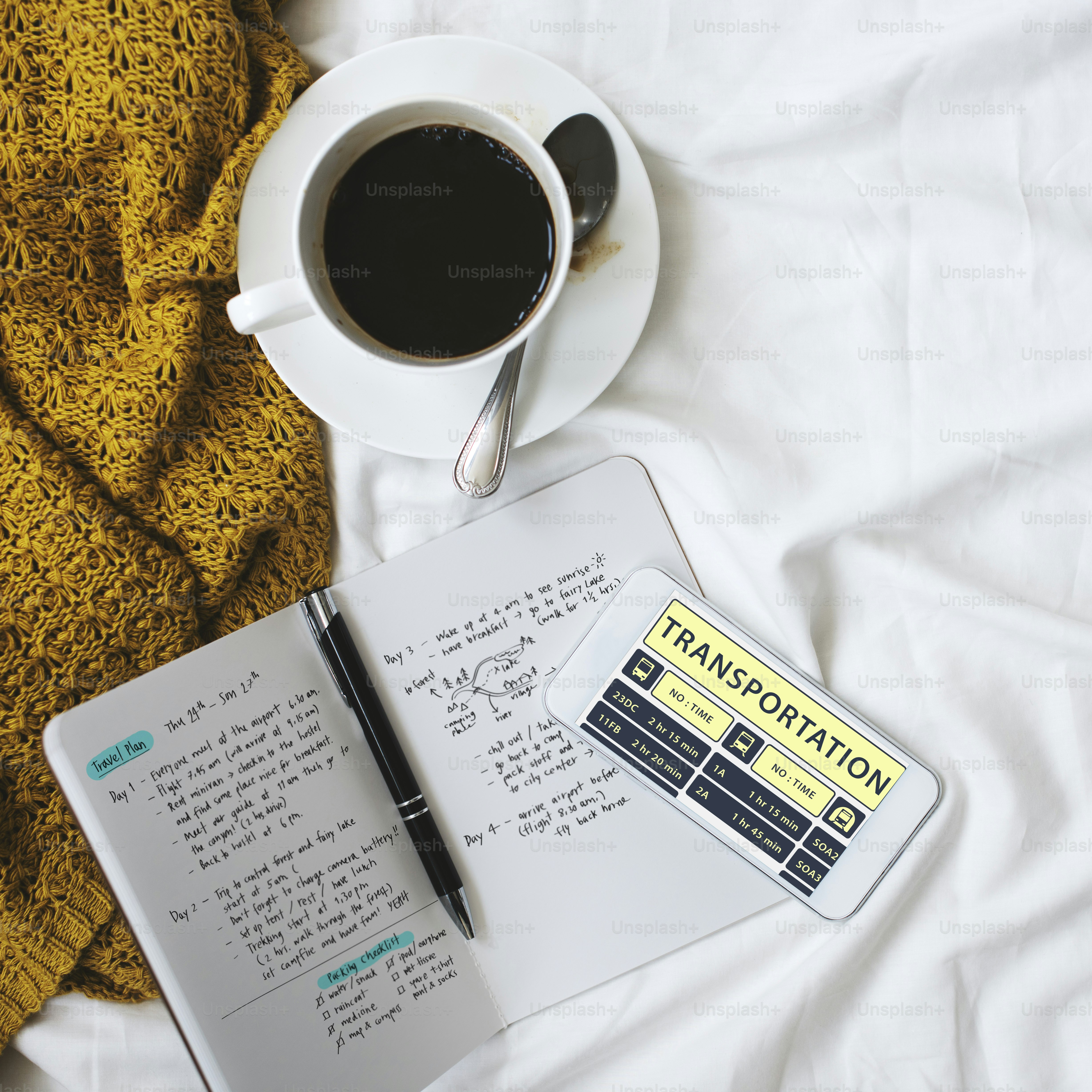 Morning coffee in bed with daily planner and mobile