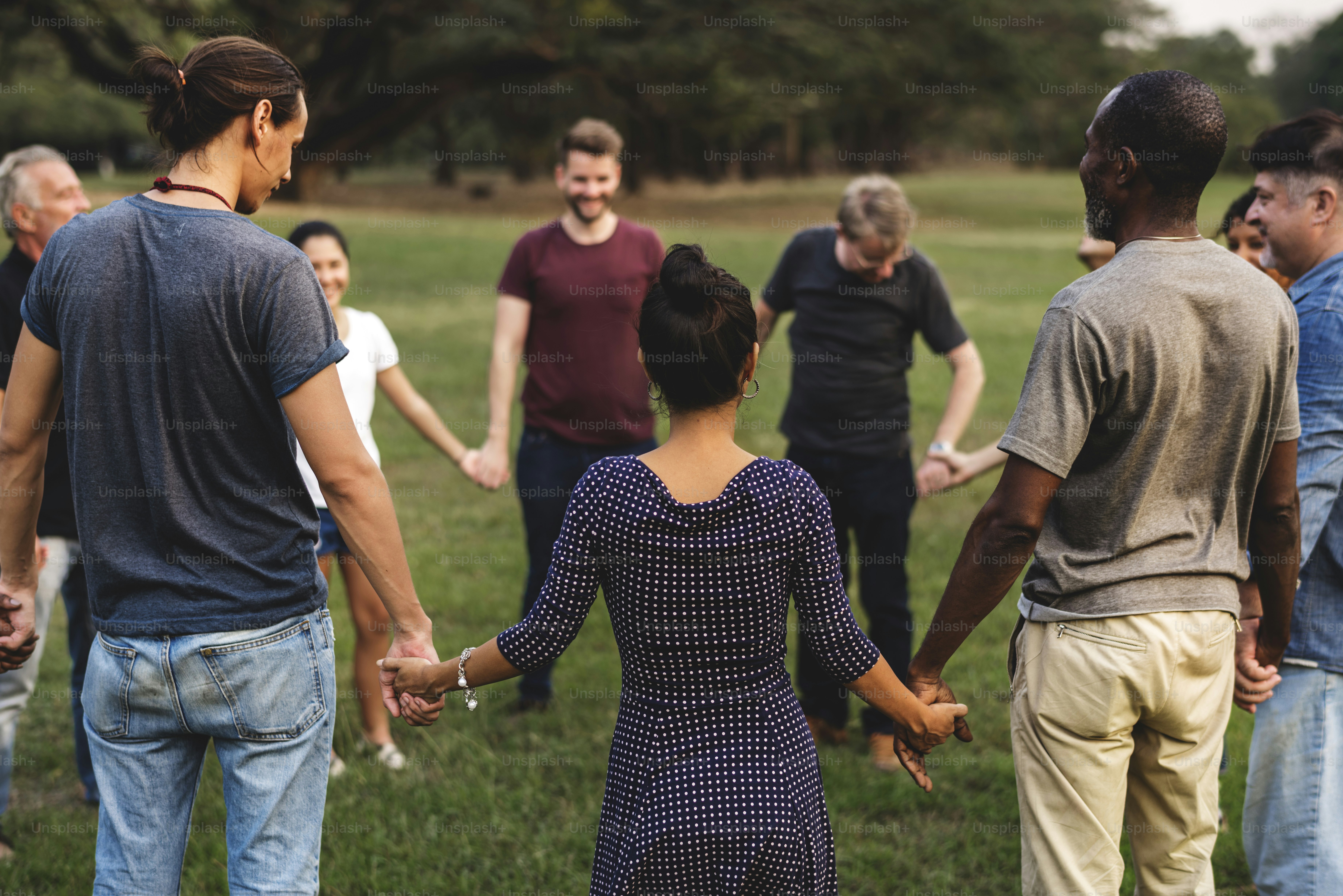 Gruppe von Menschen, die sich im Park an den Händen halten