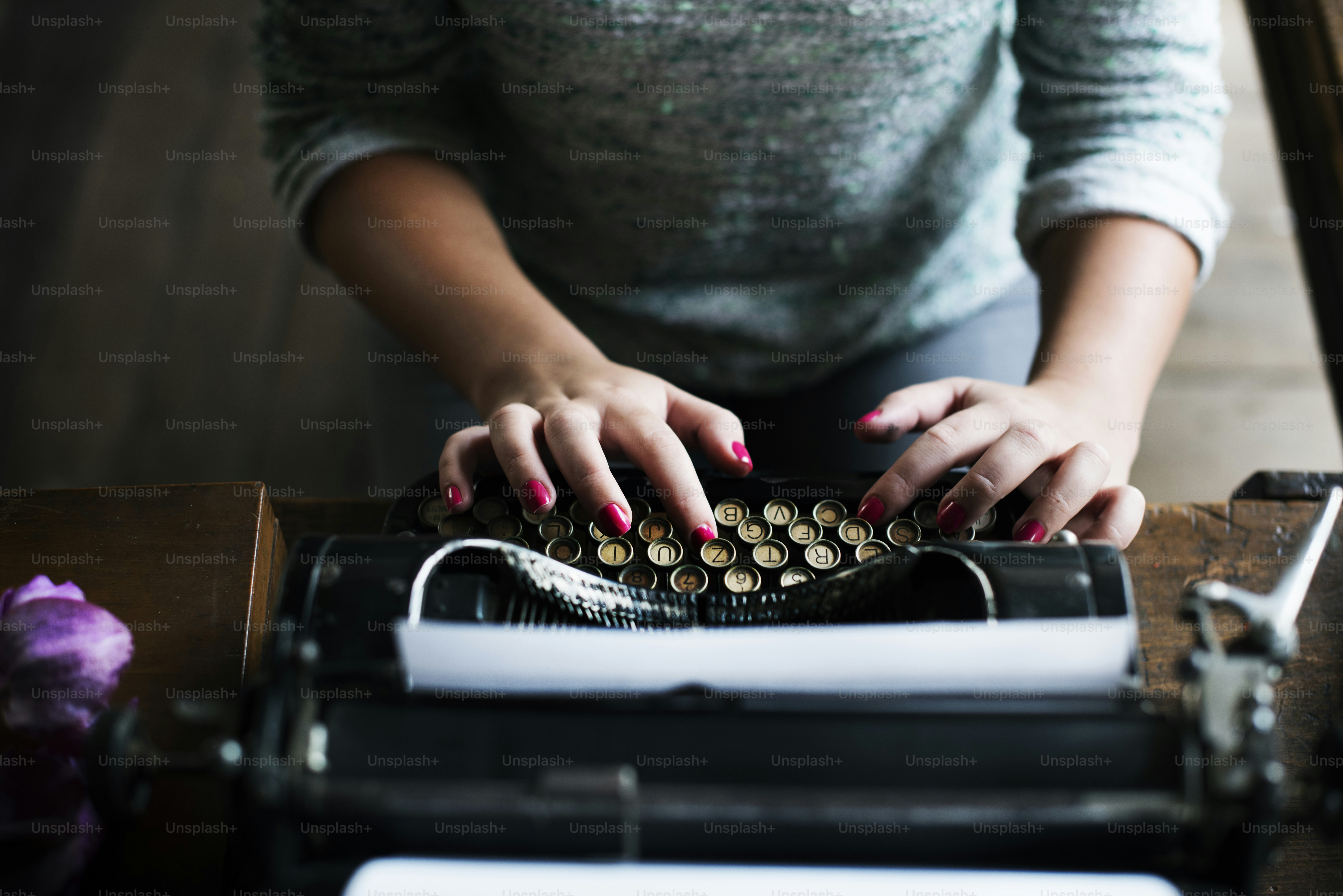 Woman typing vintage typewriter on wooden table