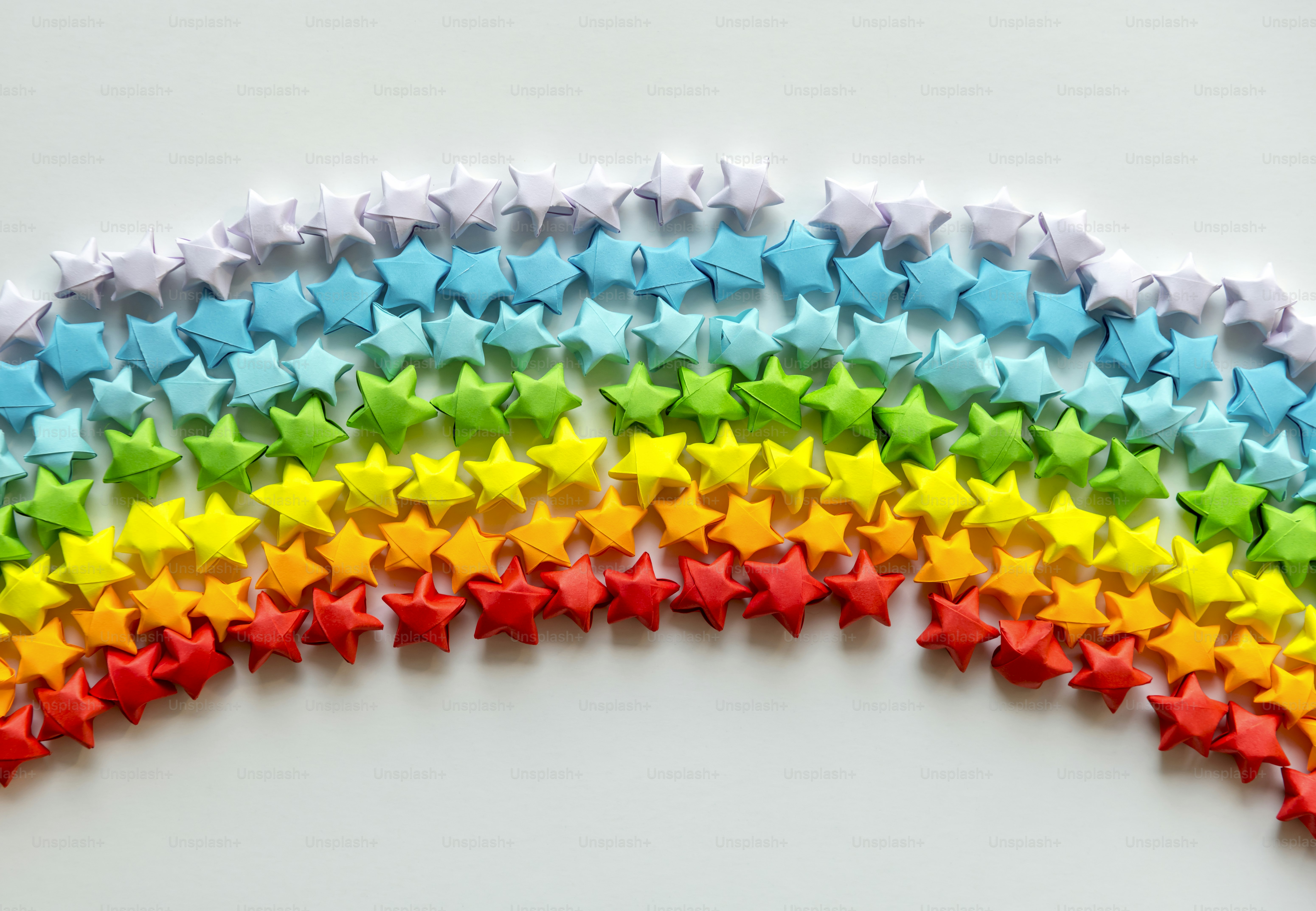 Colorful orgami stars forming a rainbow background