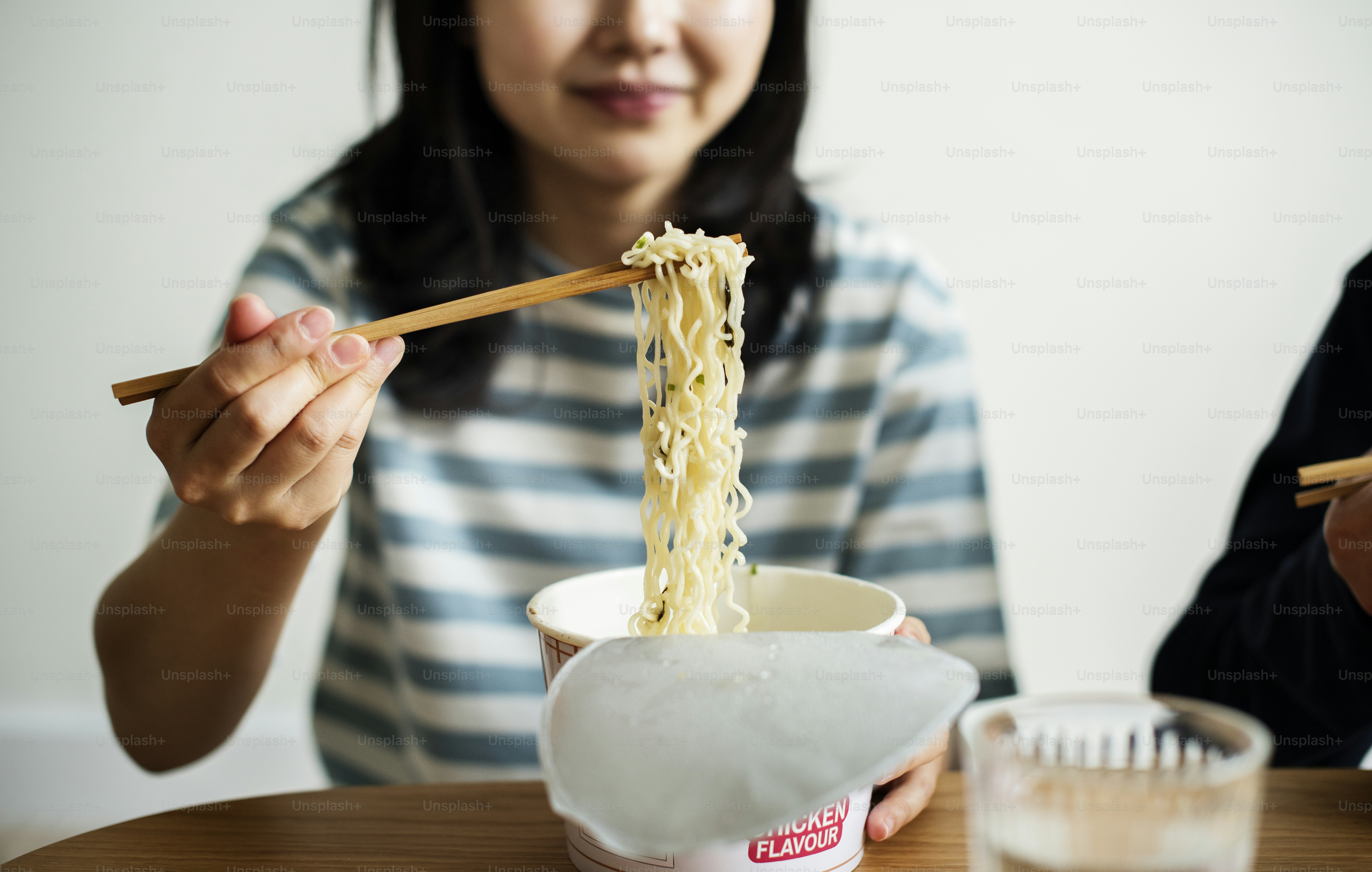 Asian ethnic woman having instant noodles