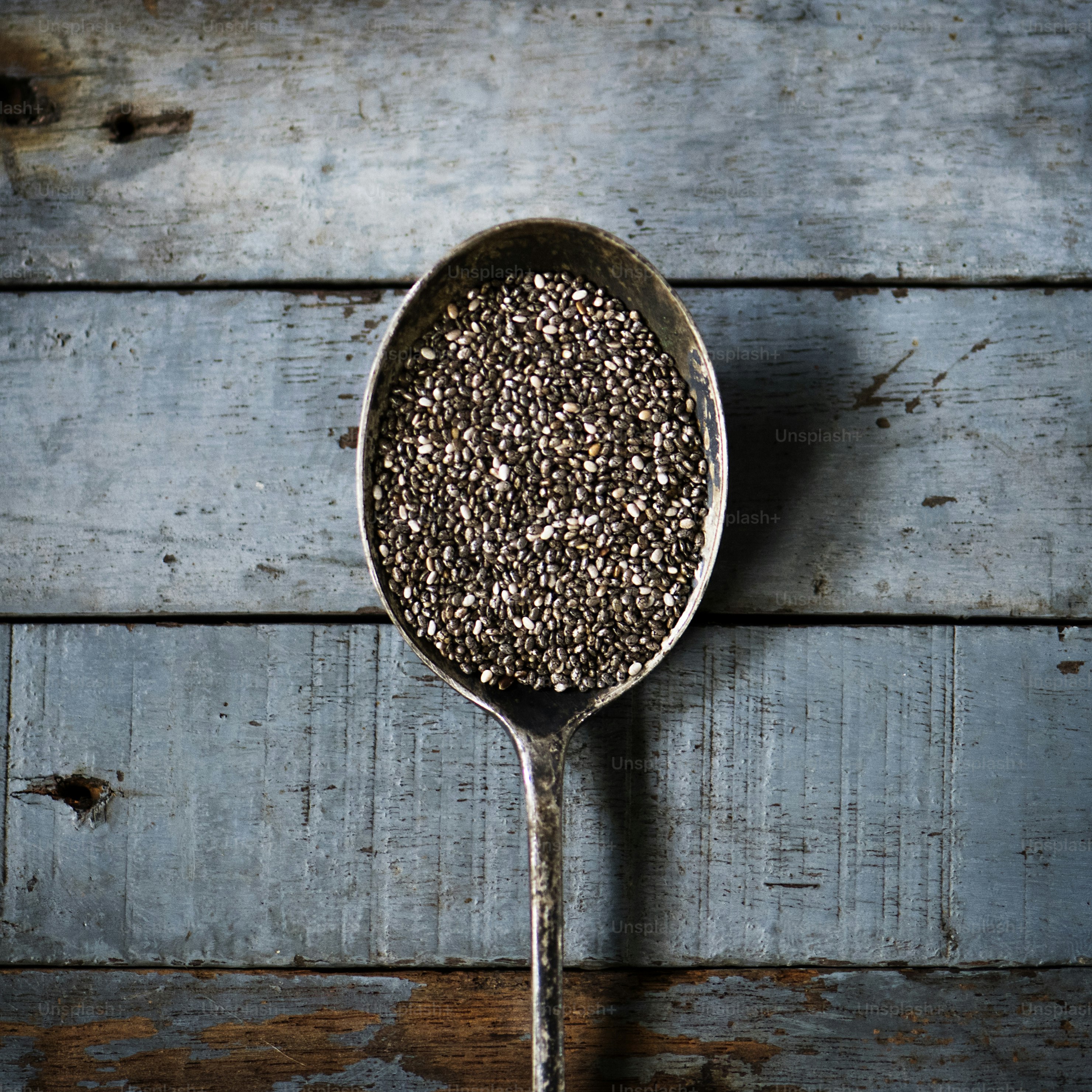 Chia seeds in spoon with wooden textured
