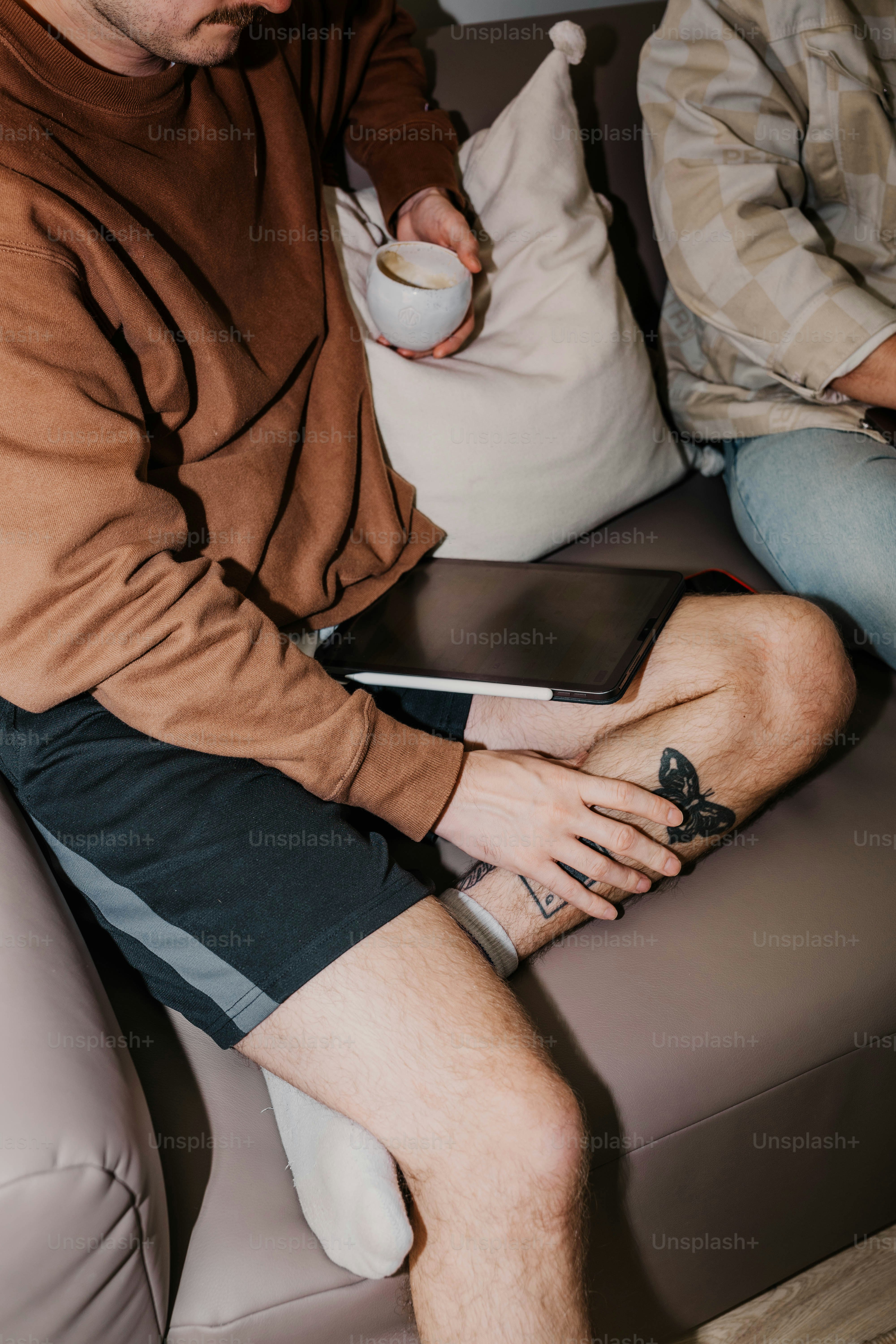 A couple of men sitting on top of a couch