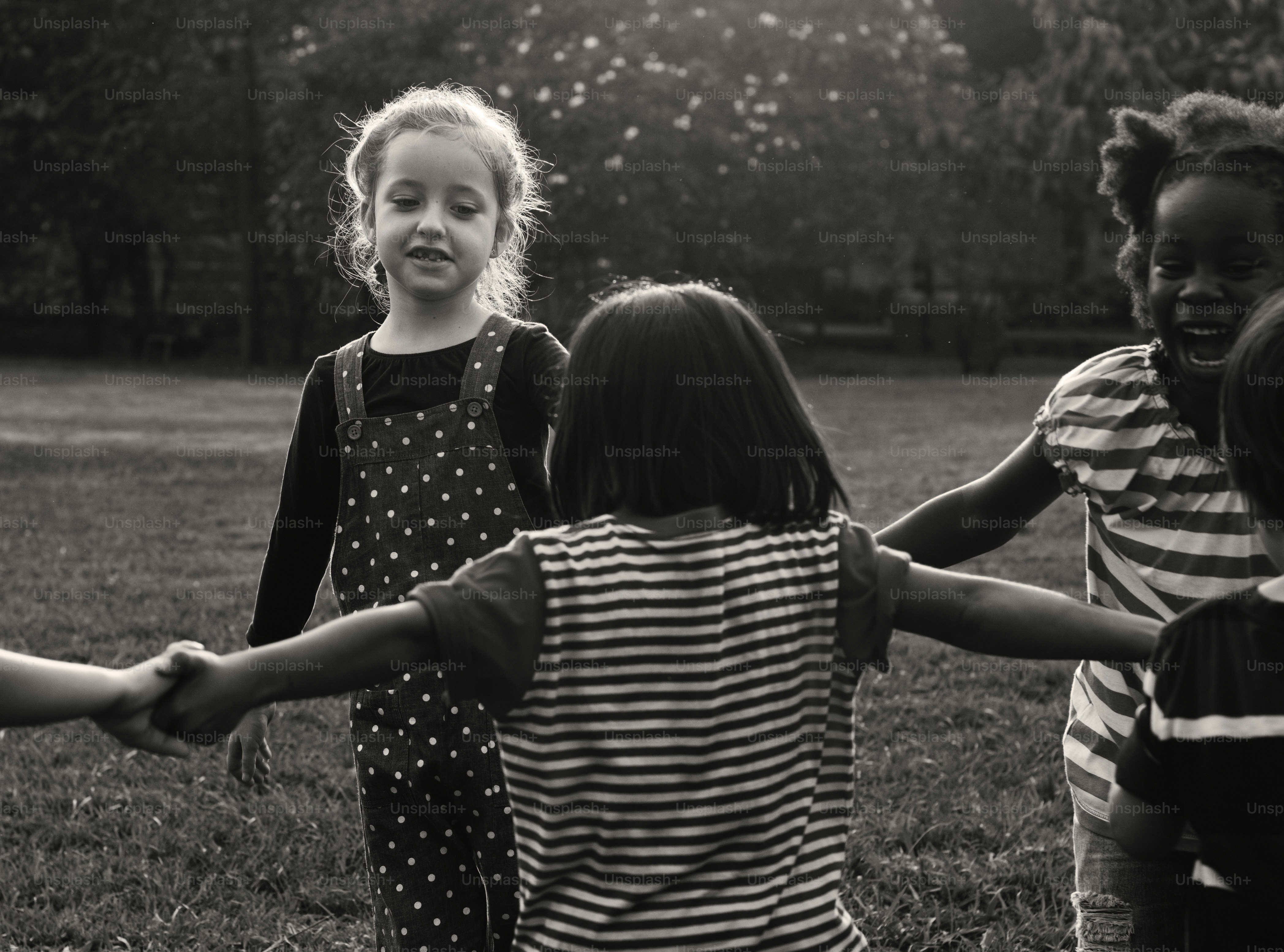 Group of kindergarten kids friends holding hands playing at park