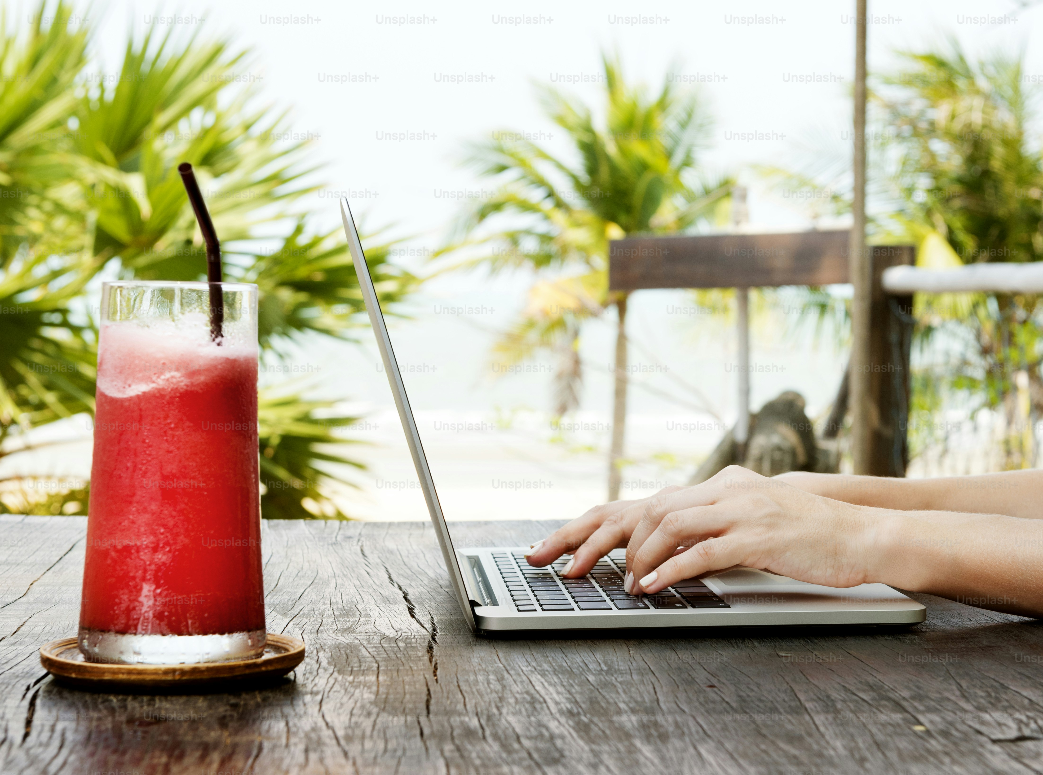 A woman is using computer laptop by the beach