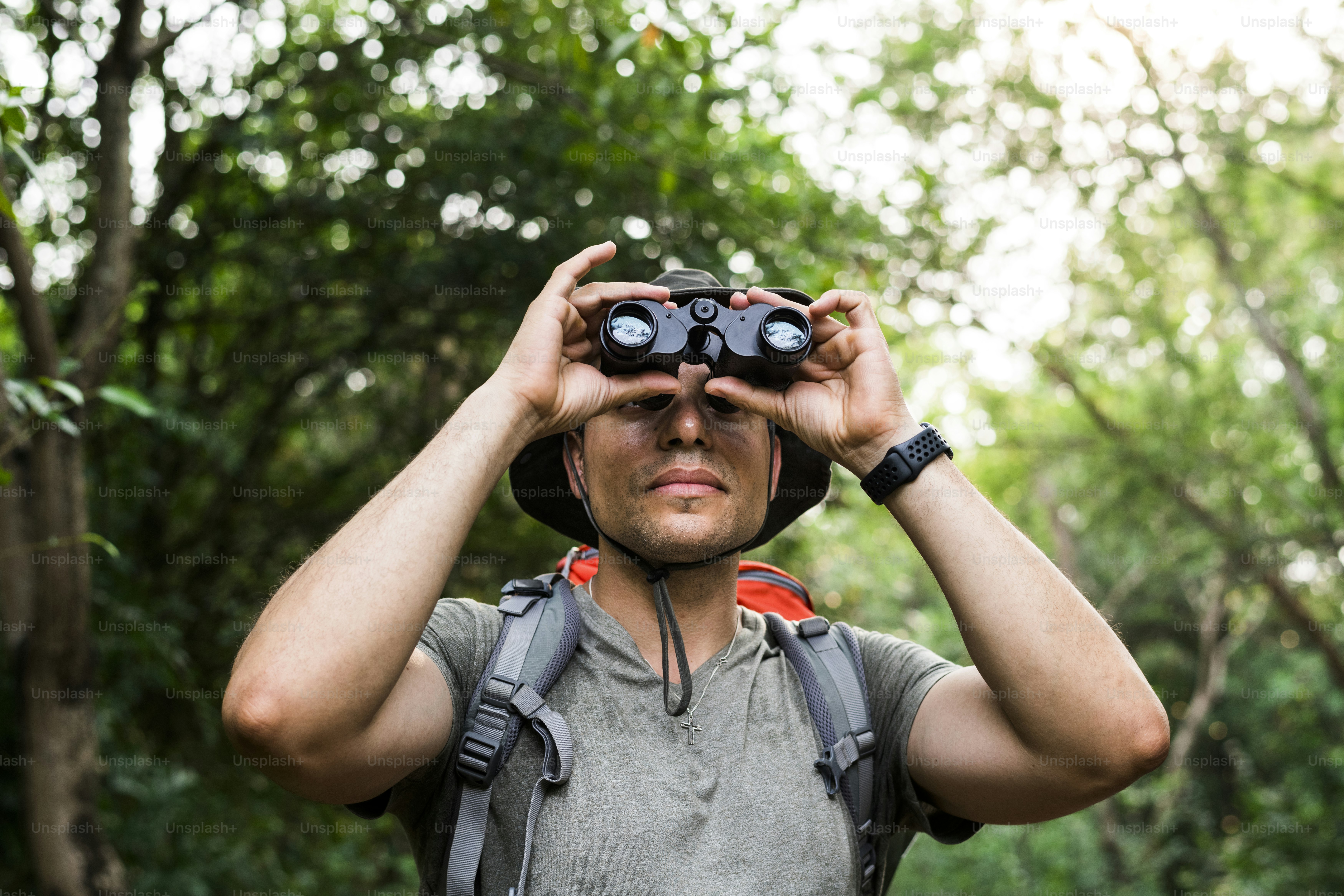Hombre sosteniendo binoculares en el bosque