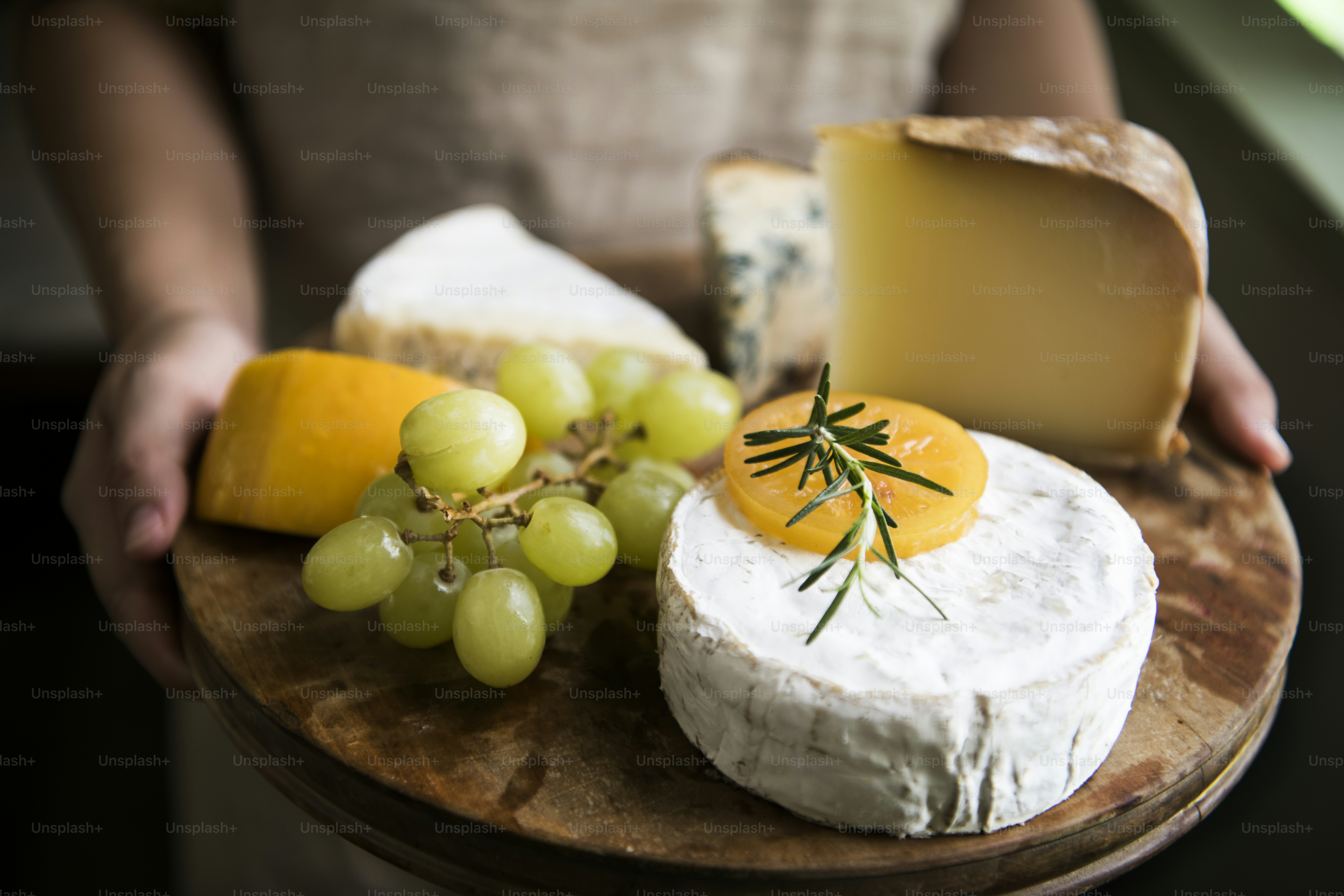 Variación de queso y uvas verdes en una fuente de madera Idea de receta de fotografía de alimentos