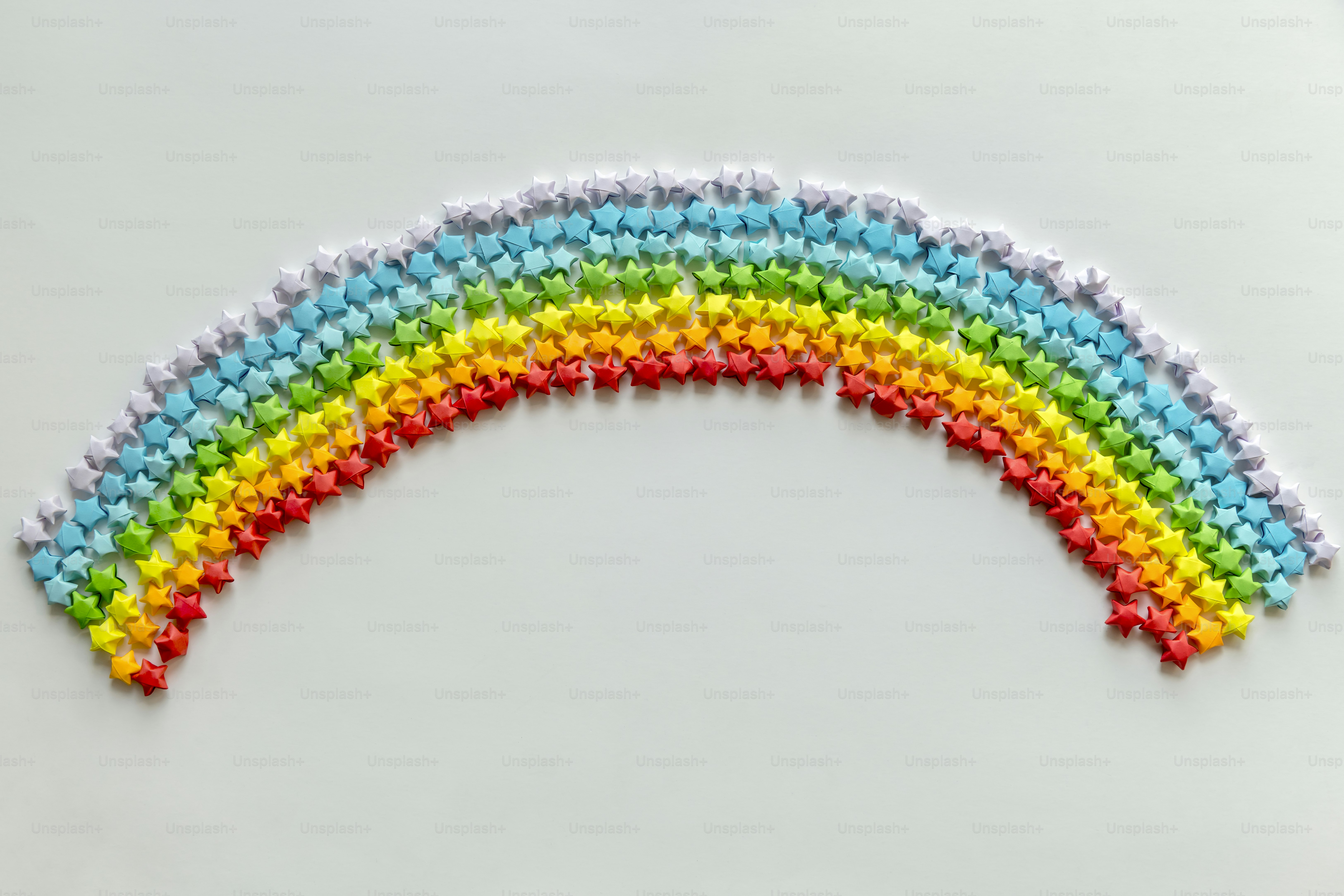 Bunte Origami-Sterne, die einen Regenbogenhintergrund bilden