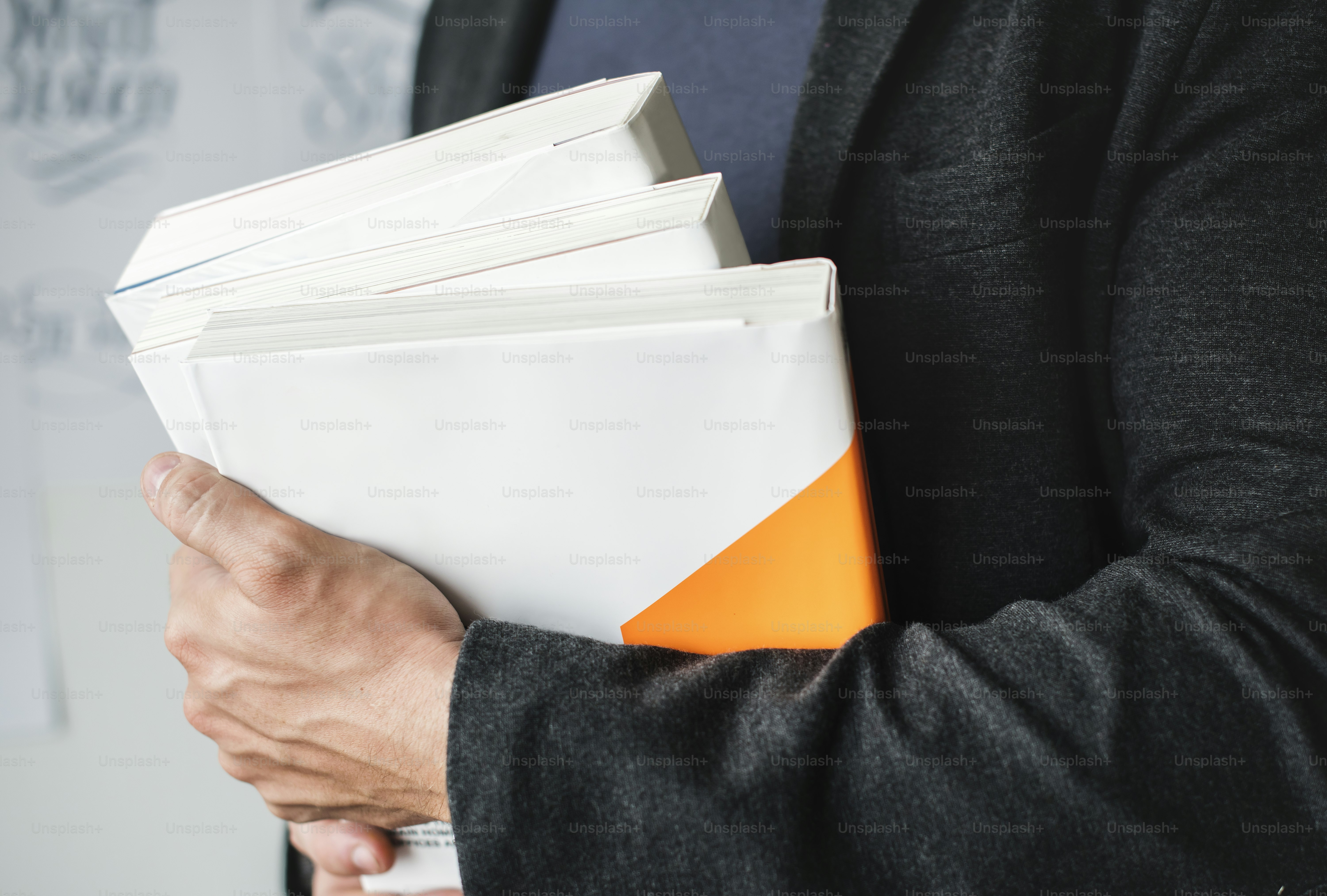 Closeup of hands holding stack of books