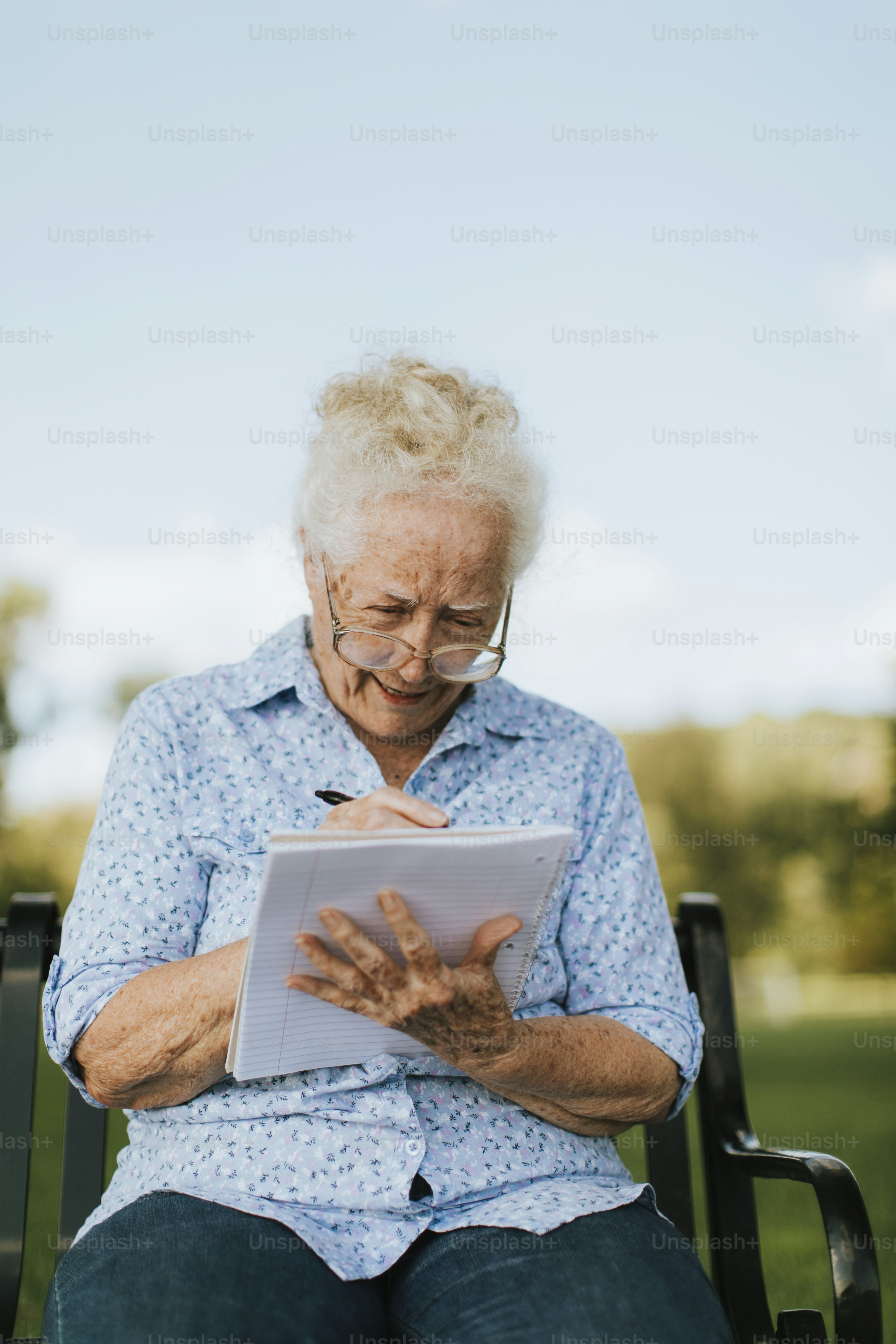 Senior woman writing down her memories into a notebook