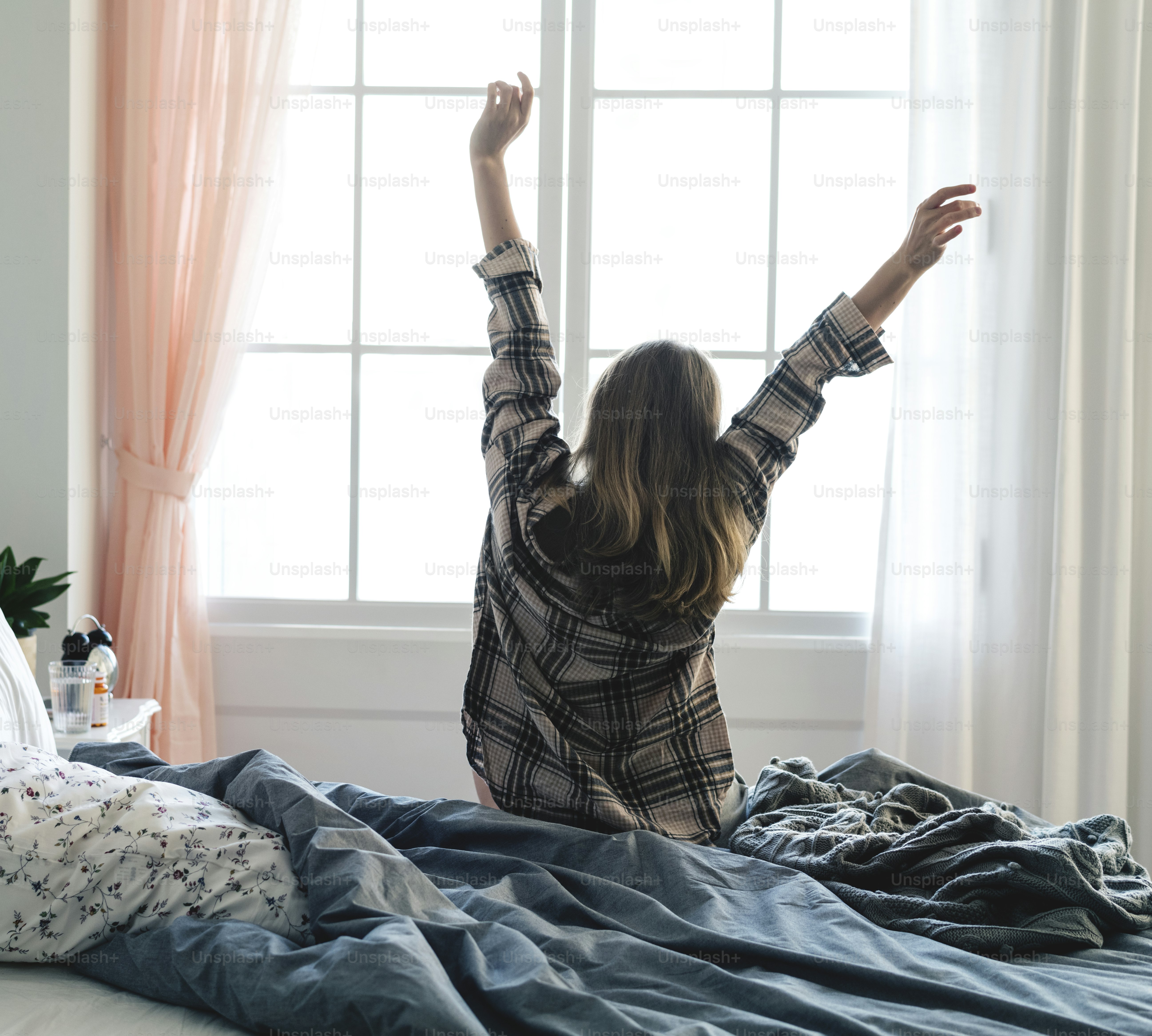Tampilan belakang wanita merentangkan tangannya di pagi hari