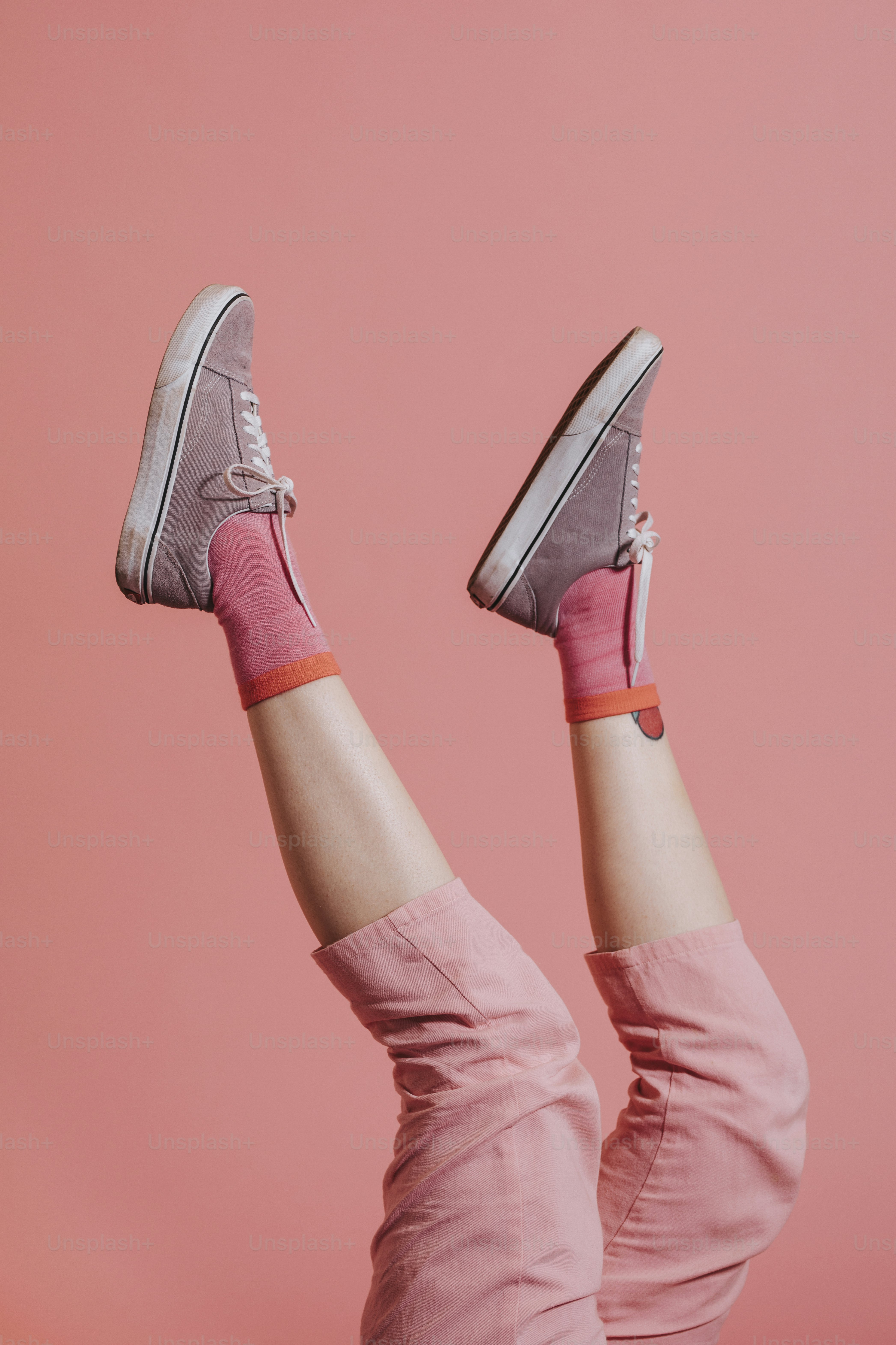 Pés da mulher em calças cor-de-rosa acima no ar