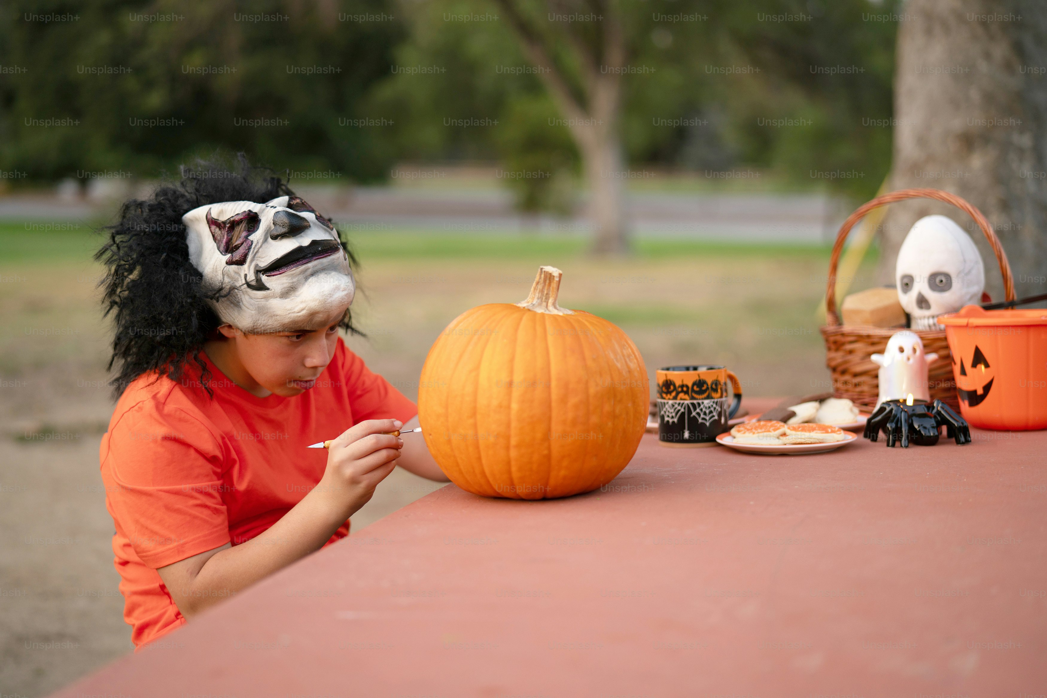 A woman sitting at a table with a pumpkin