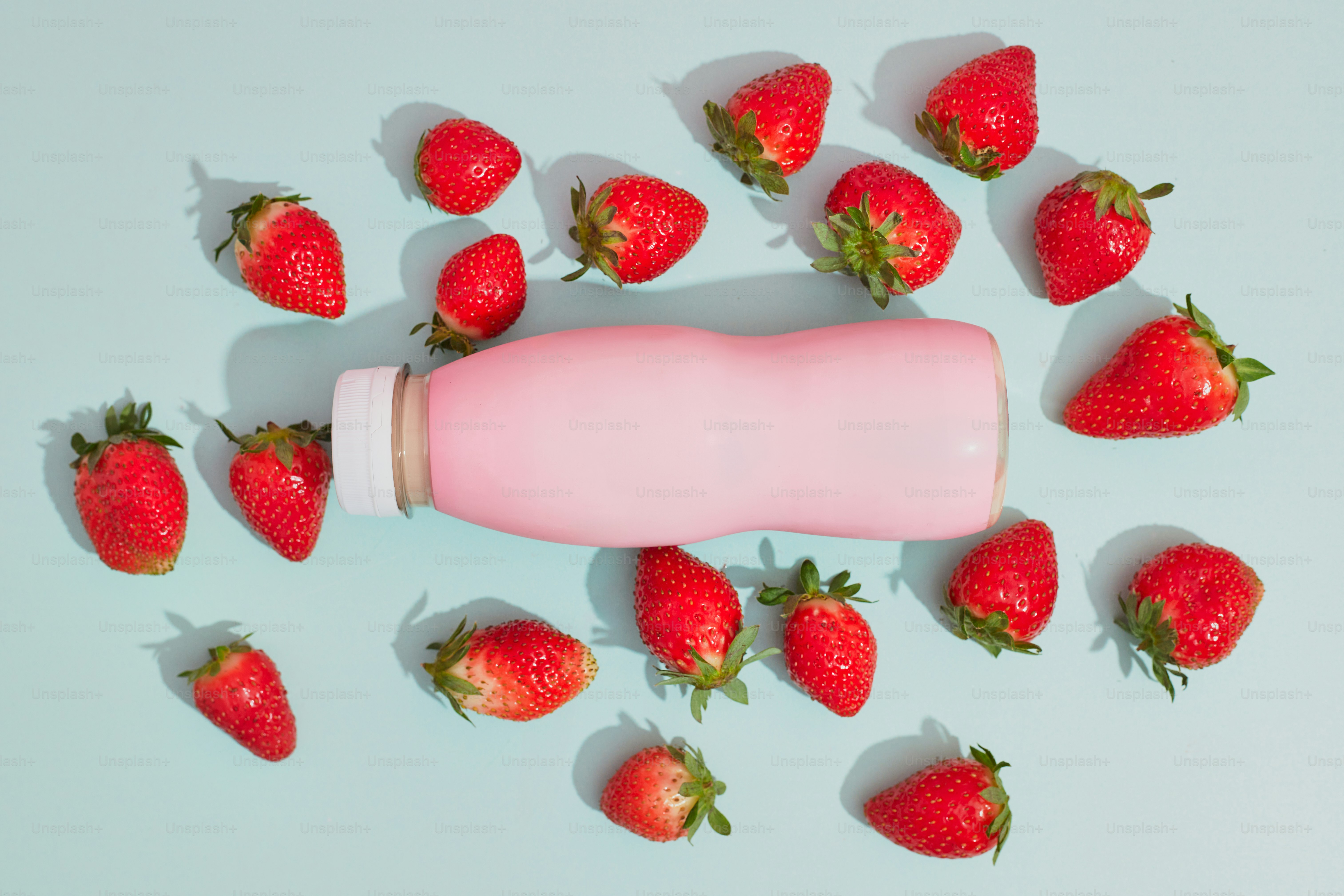 A tube of toothpaste surrounded by strawberries