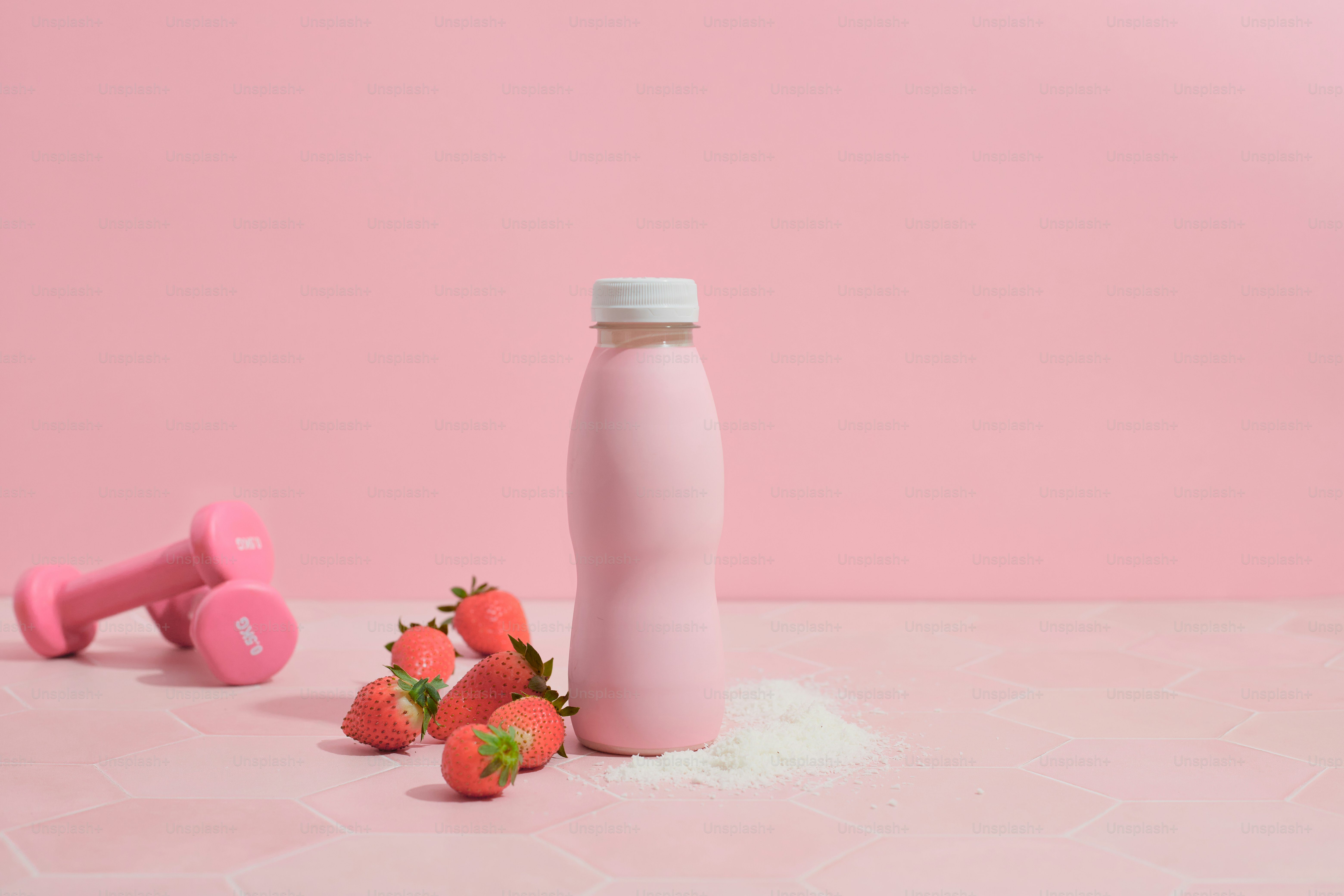 Una bottiglia rosa e alcune fragole su un tavolo